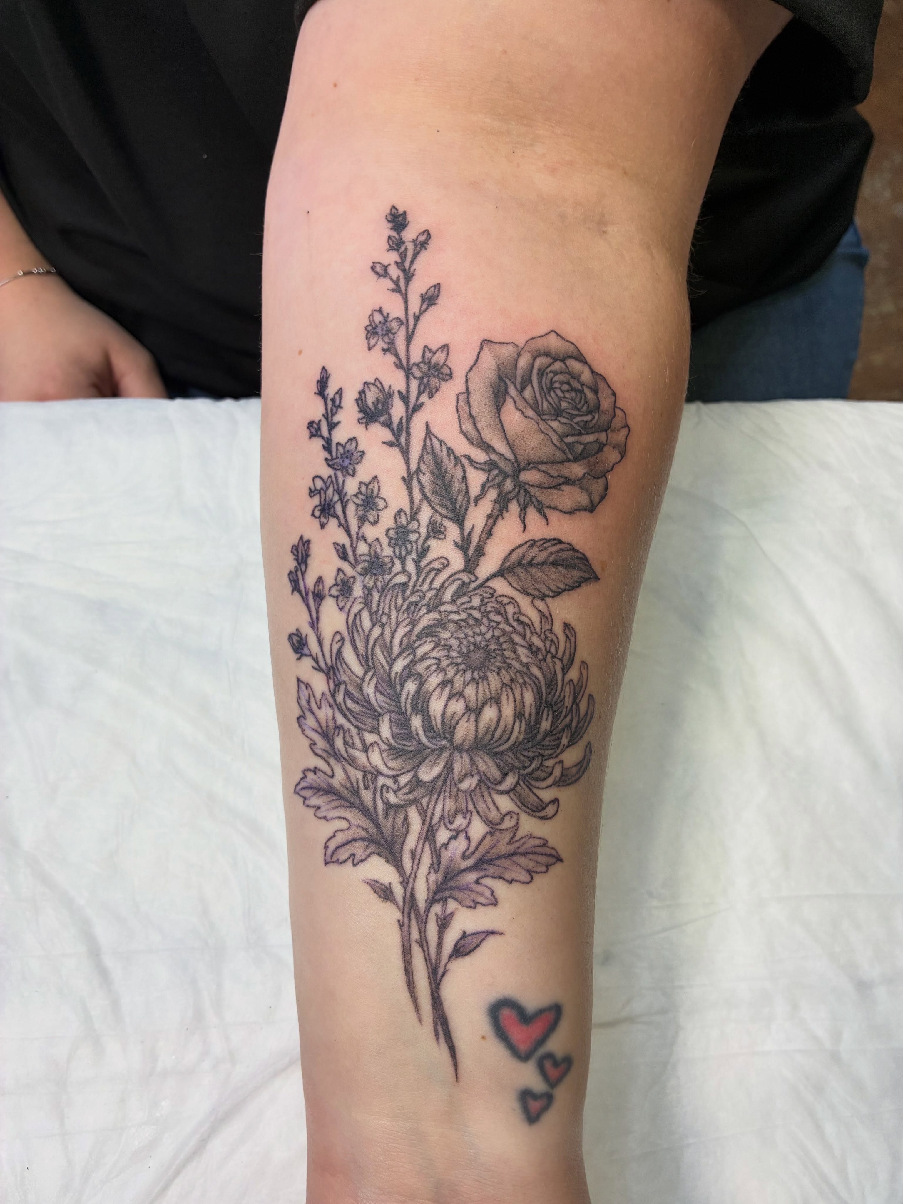 Floral bouquet realism tattoo on the forearm by Heather Freitag
