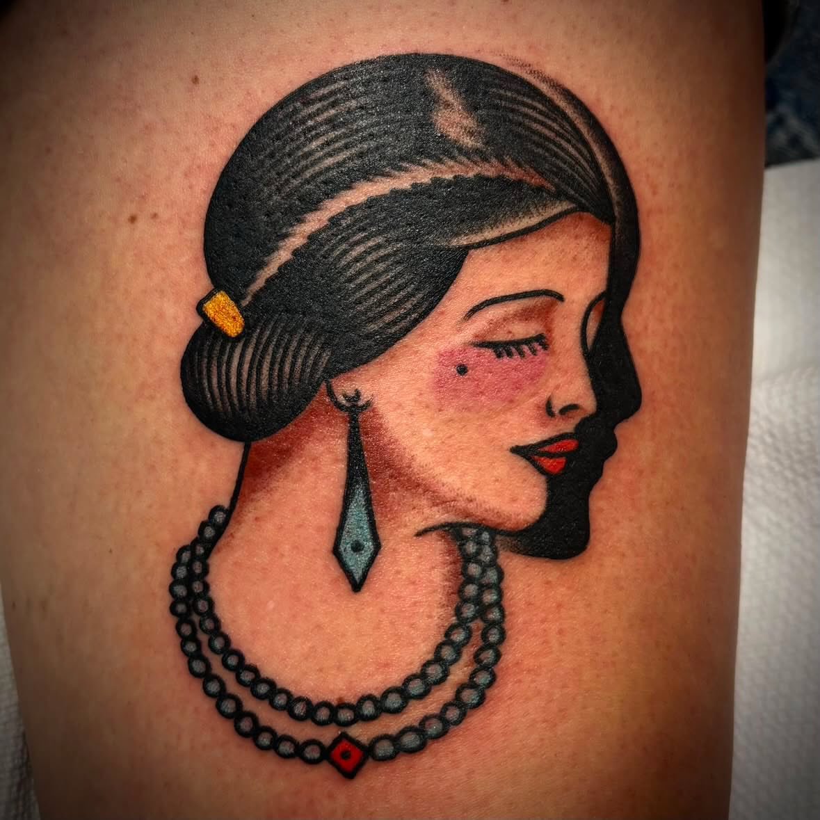 Woman profile American traditional tattoo on the thigh by Danny DiBlasi, San Francisco, California
