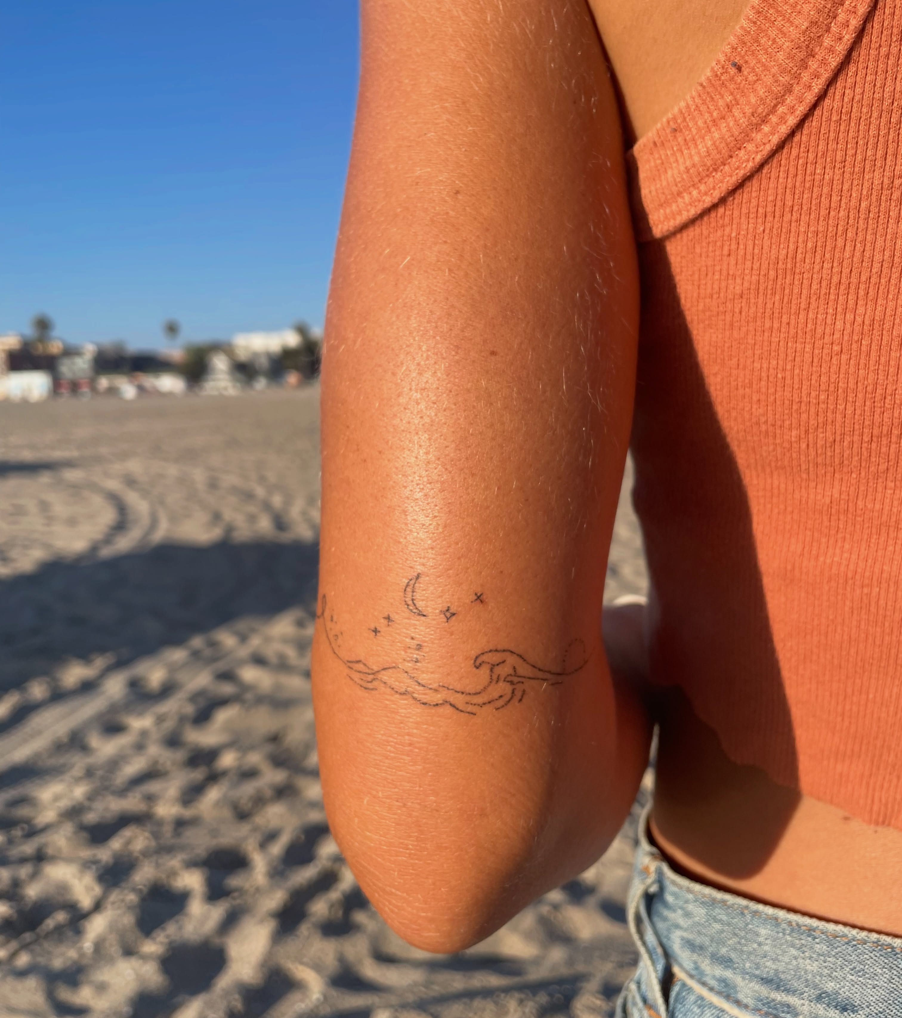 Wave and crescent moon fine line tattoo on the forearm by Alyssa