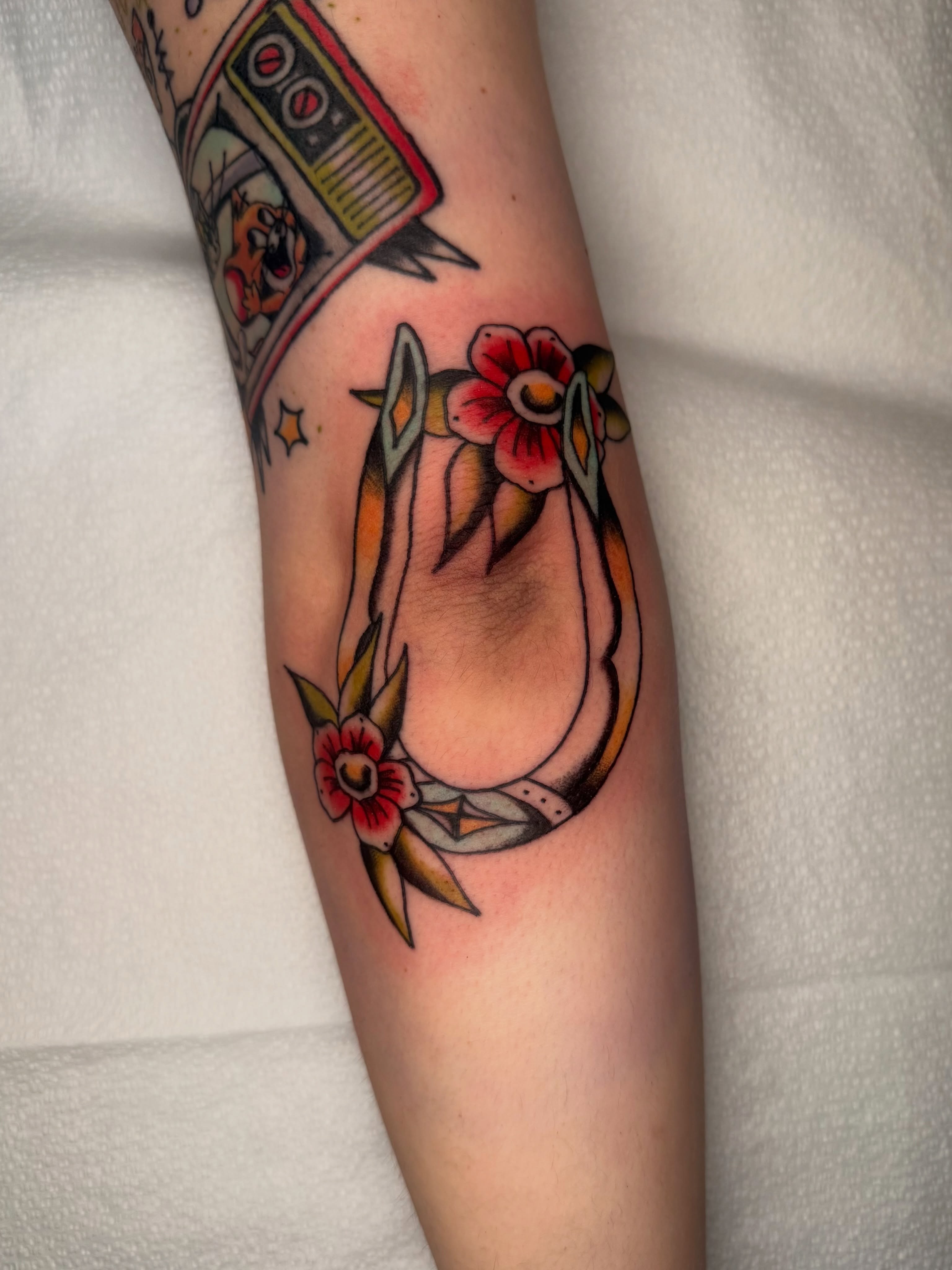 Flower wreath American traditional tattoo on the forearm by Lexie Graff