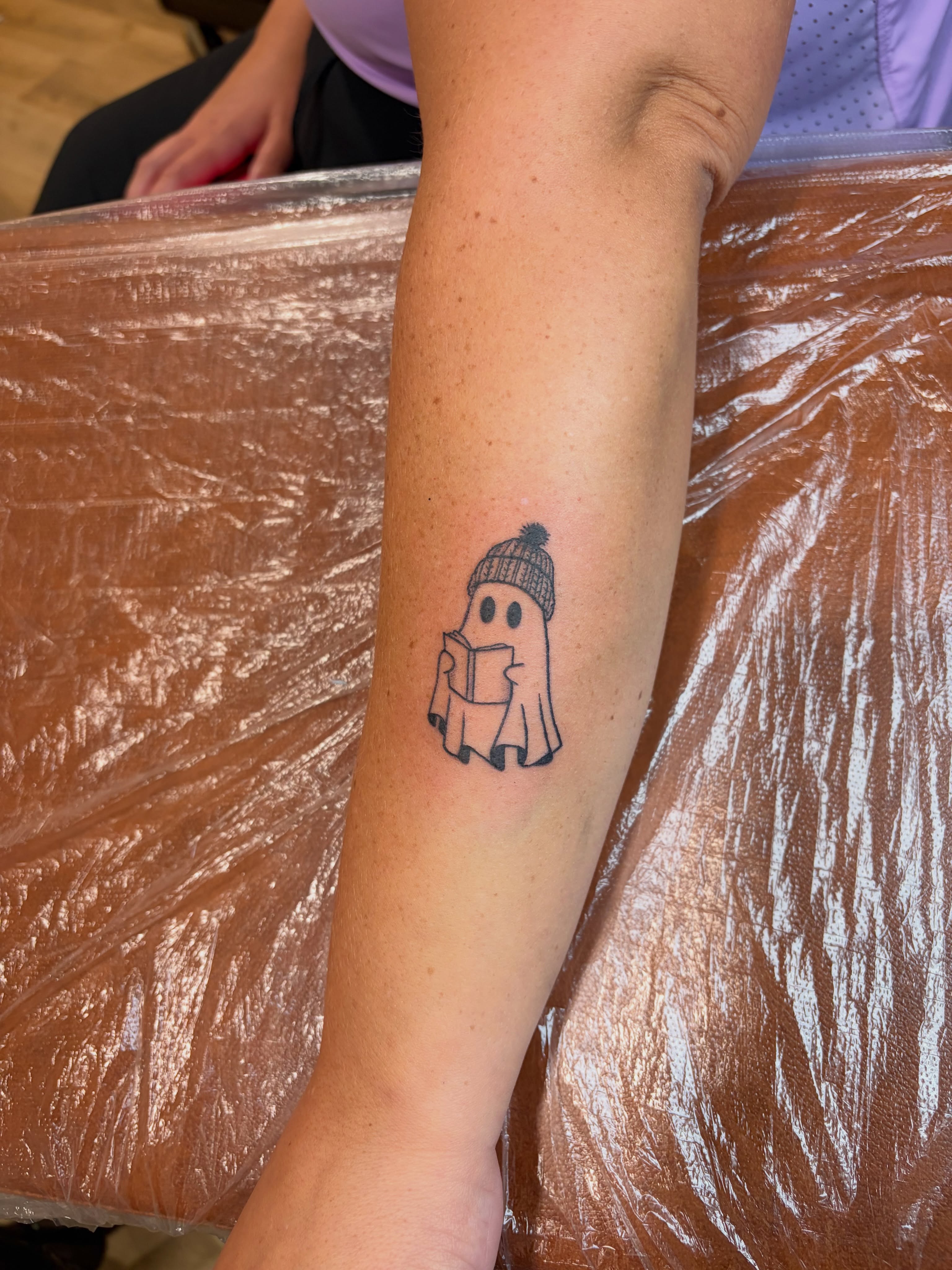 Ghost reading book dotwork tattoo on the forearm by Emily, Monticello, Iowa