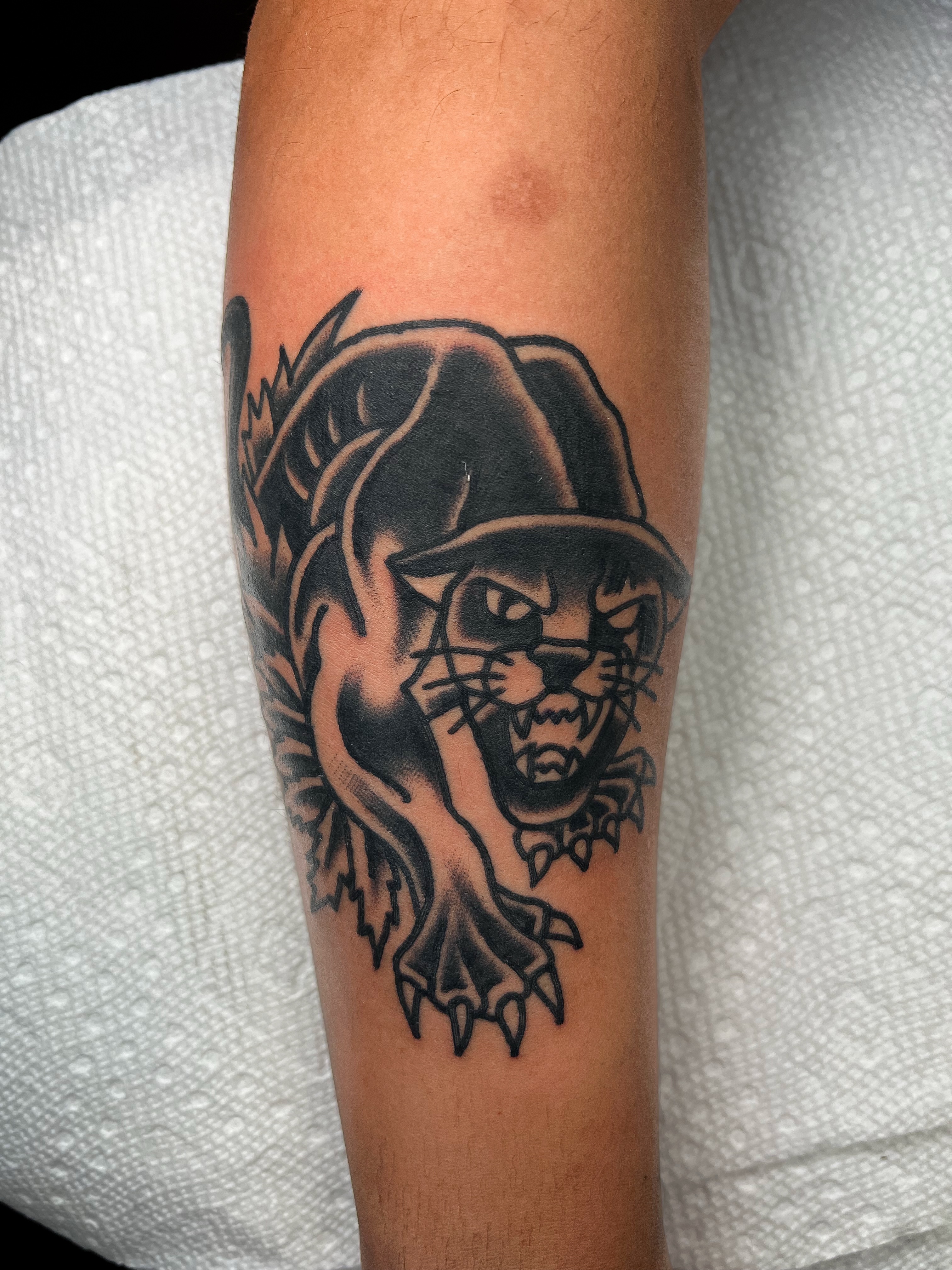 Panther black and grey tattoo on the forearm by Nestor Zelaya