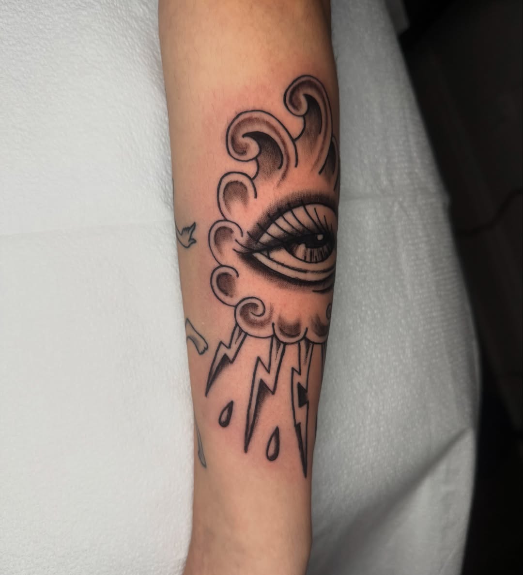 Eye with cloud American traditional tattoo on the forearm by Lexie Graff