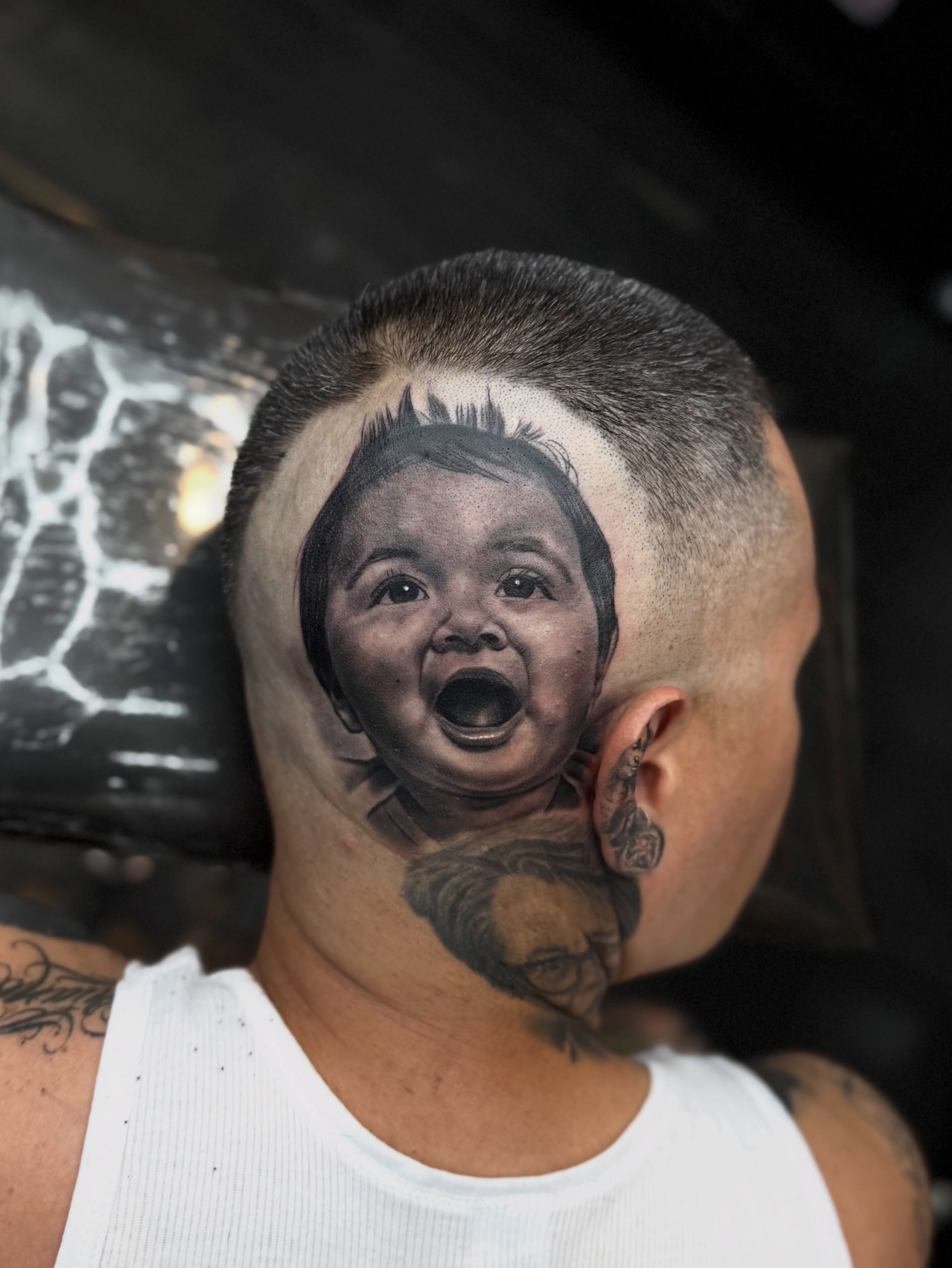 Baby's face realism tattoo on the head by Luis Peña