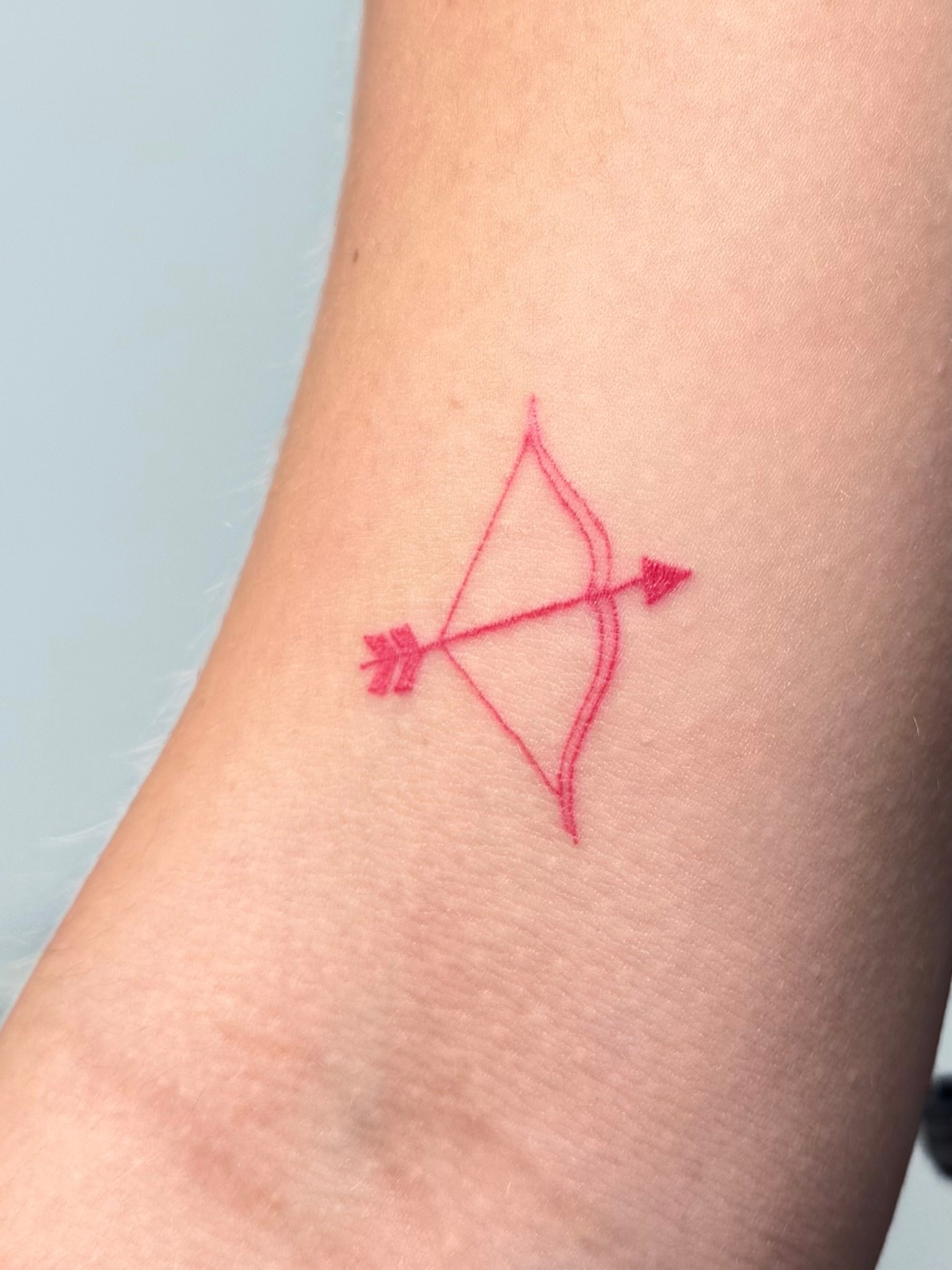 Bow and arrow geometric tattoo on the forearm by Nicole