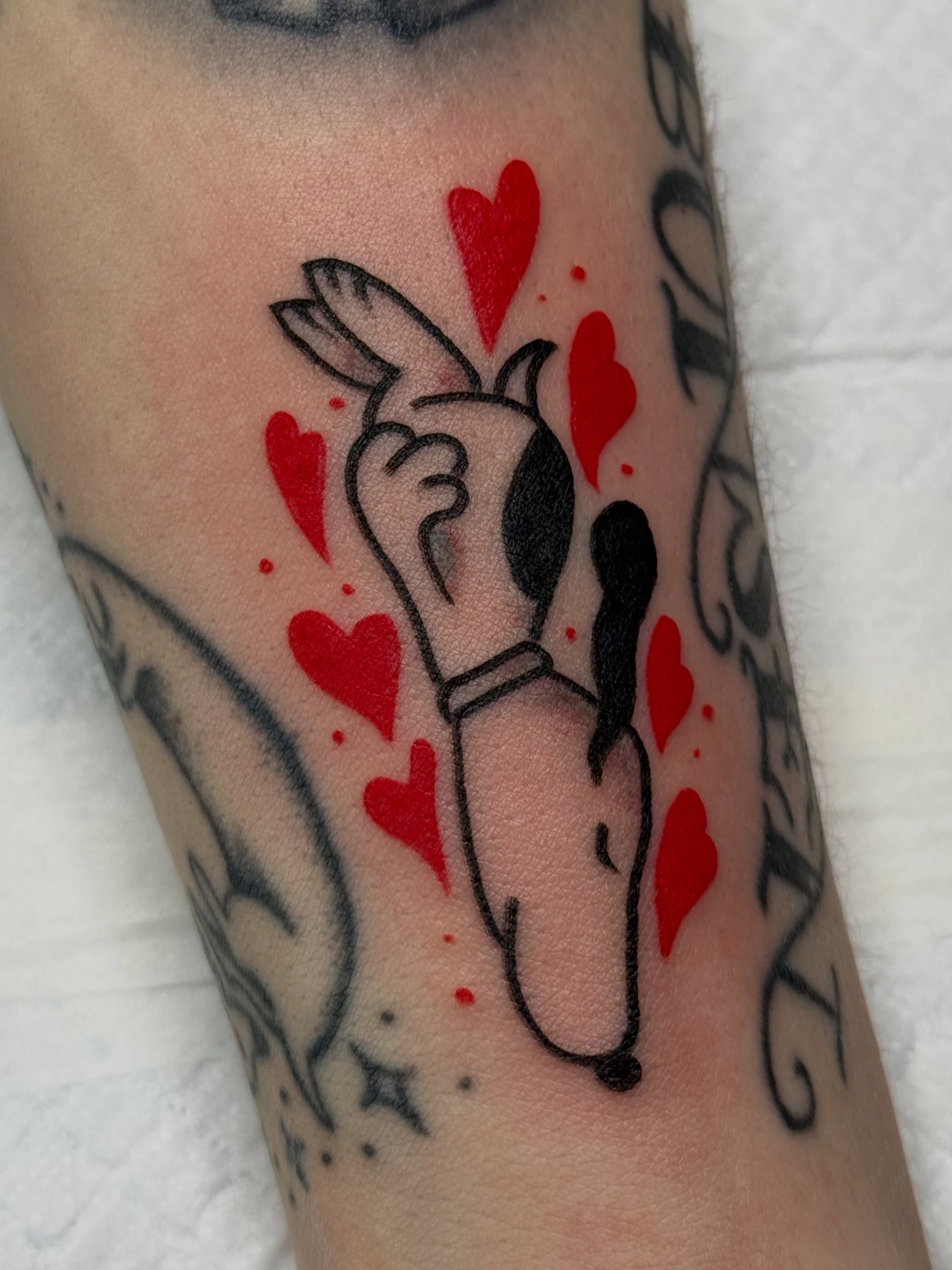 Dog with hearts dotwork tattoo on the forearm by Chelsea Graham, Seattle, Washington