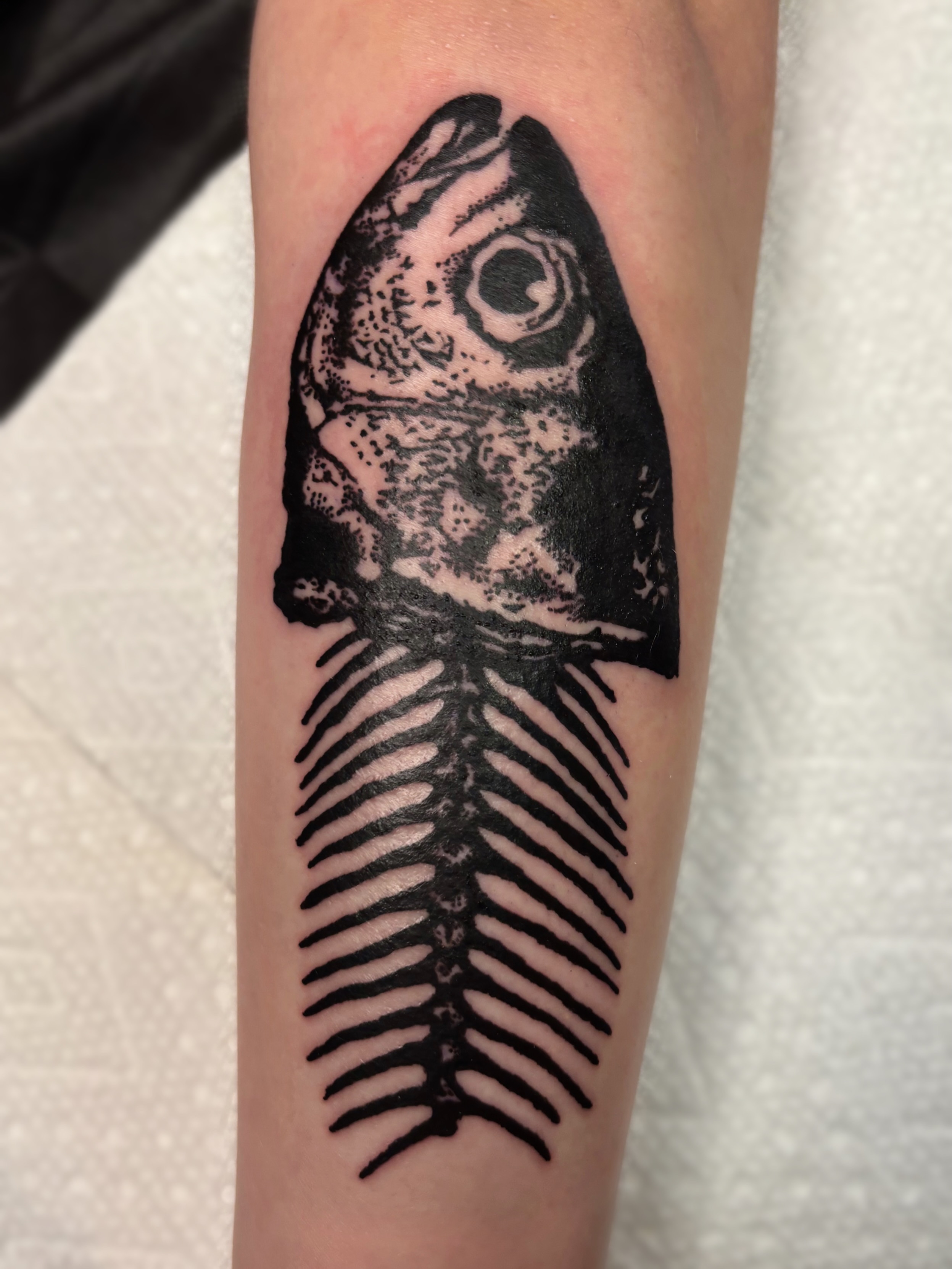 Fish skeleton black and grey tattoo on the forearm by Cooper, Portland, Oregon
