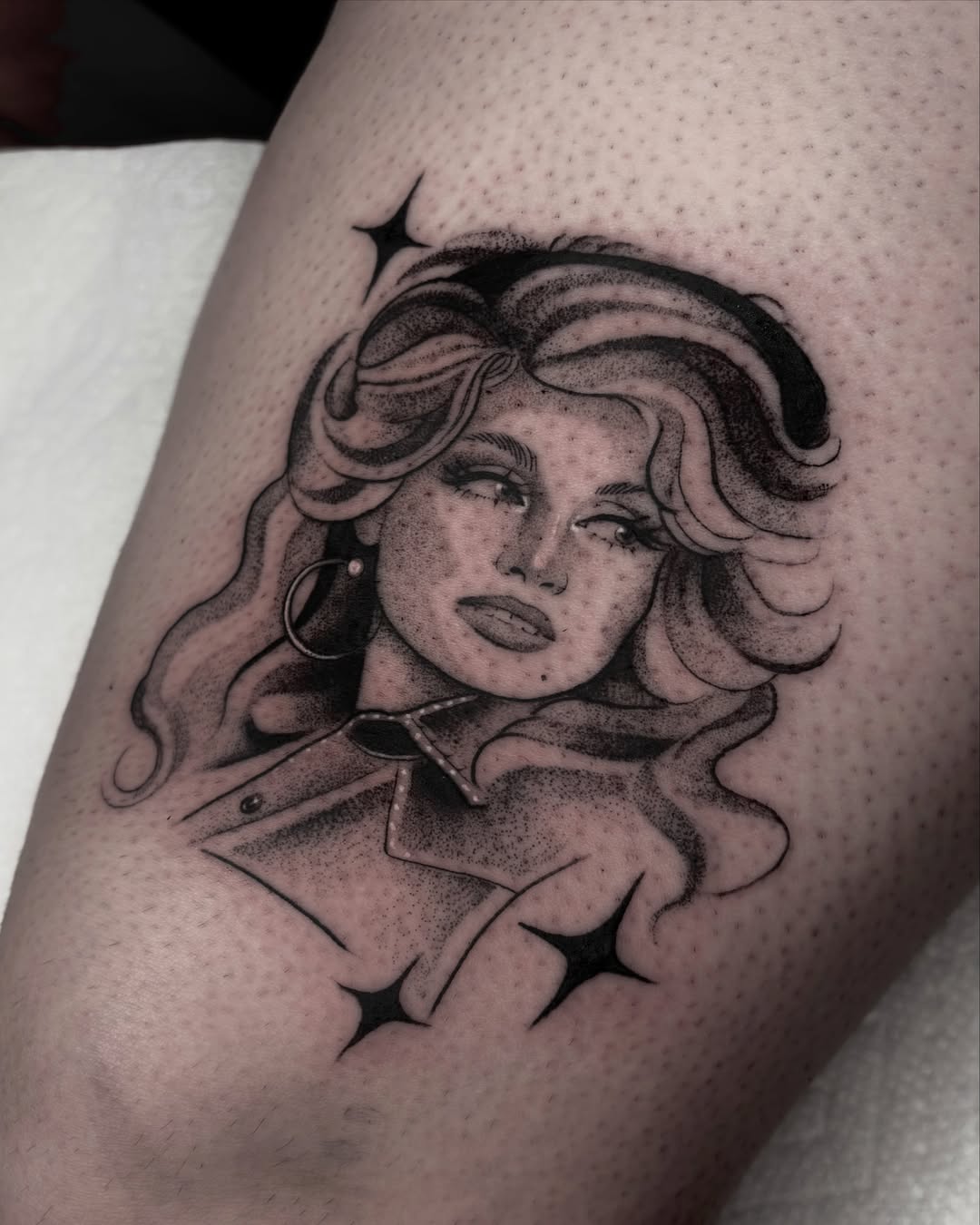 Woman with curly hair dotwork tattoo on the thigh by Avery Mullins