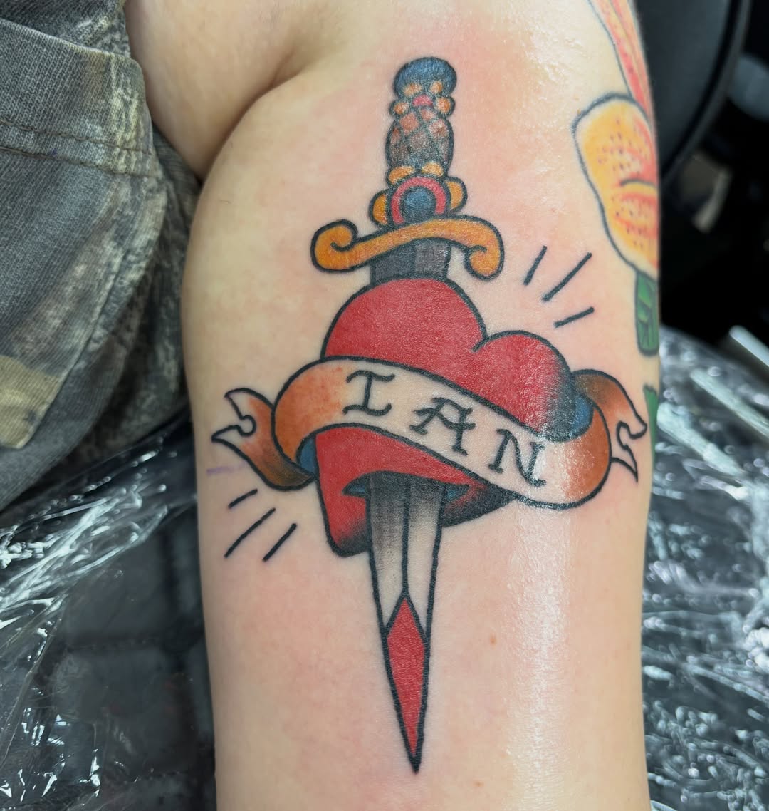 Heart with dagger American traditional tattoo on the forearm by Natalie Opal🪻🍎🫖