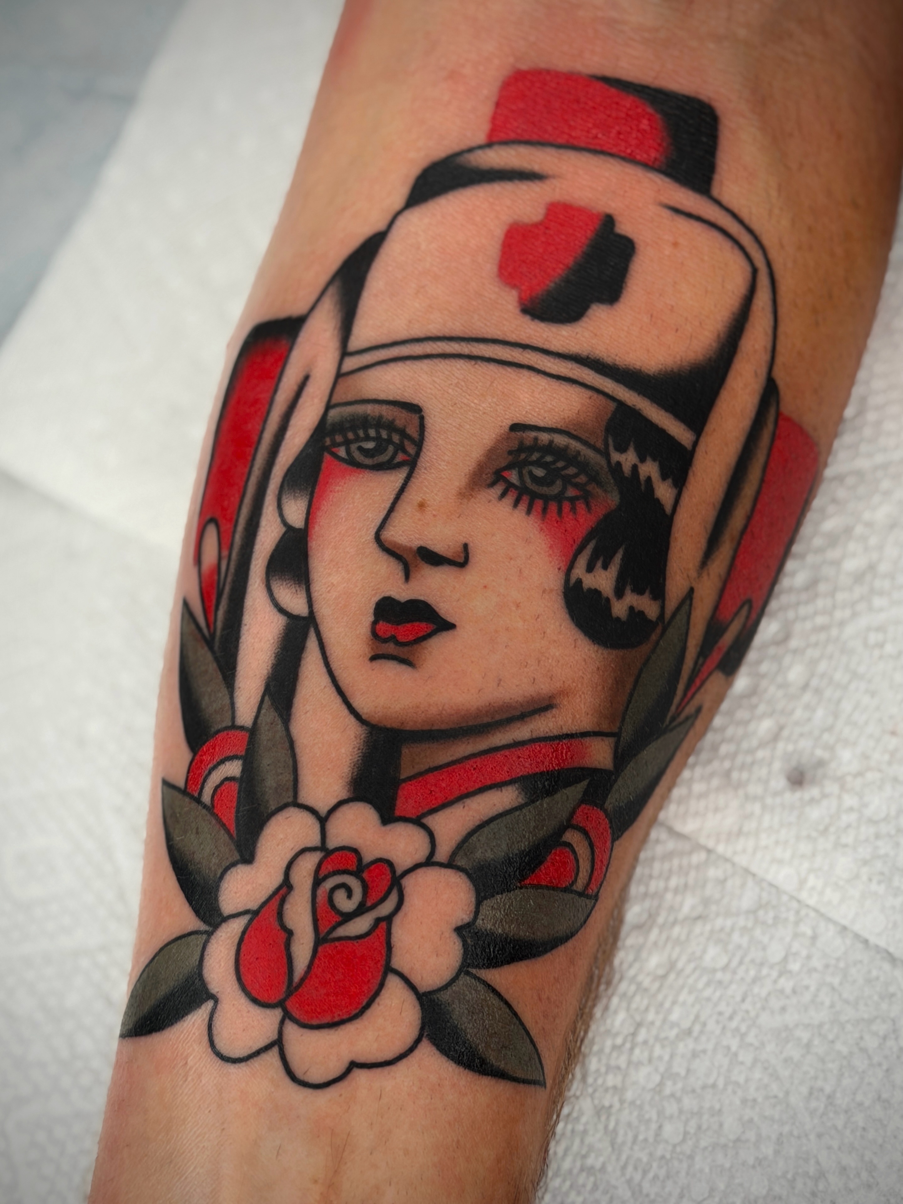 Nurse with roses American traditional tattoo on the forearm by Diego Treviño