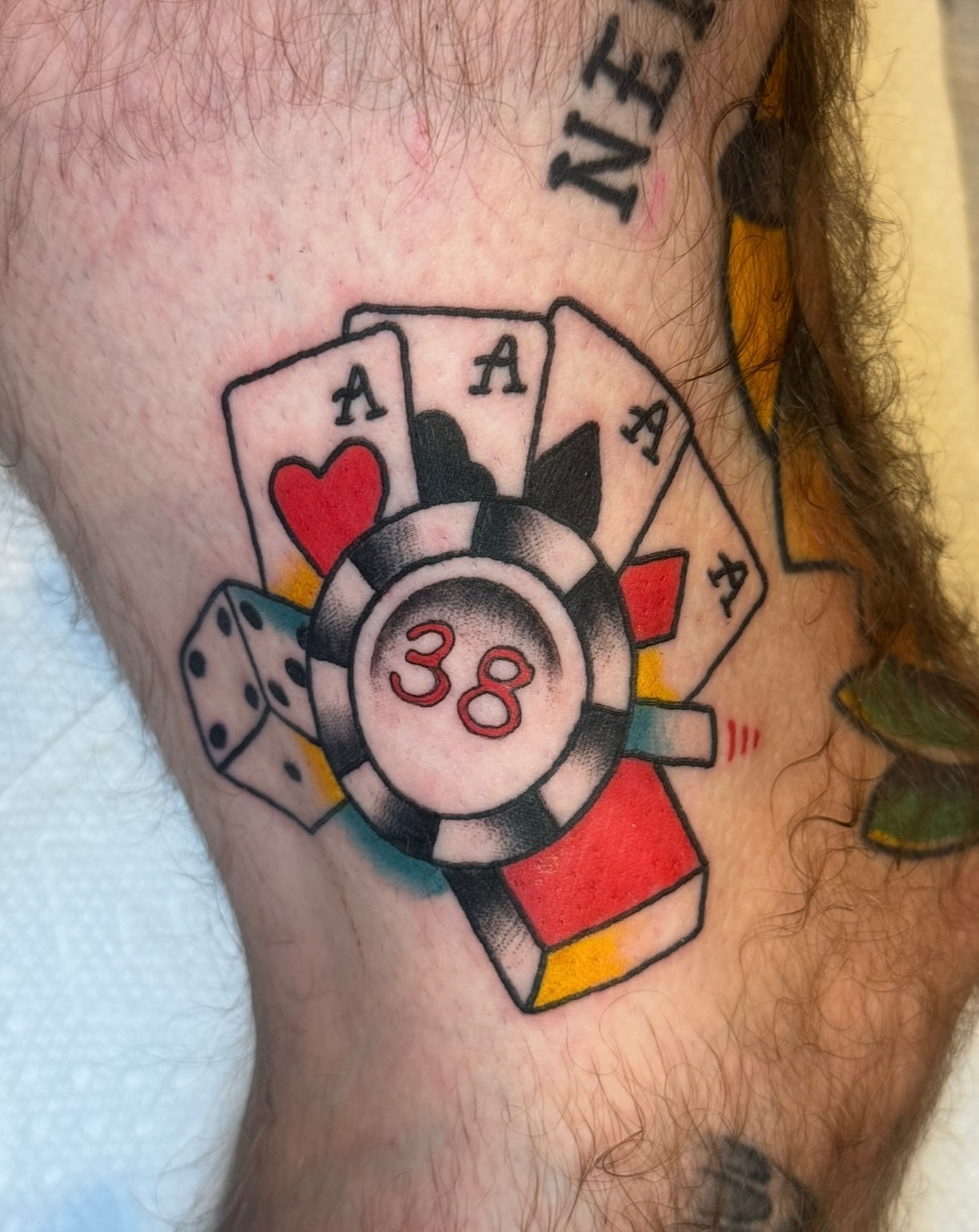 Playing cards and poker chip American traditional tattoo on the forearm by Kenneth Gibson