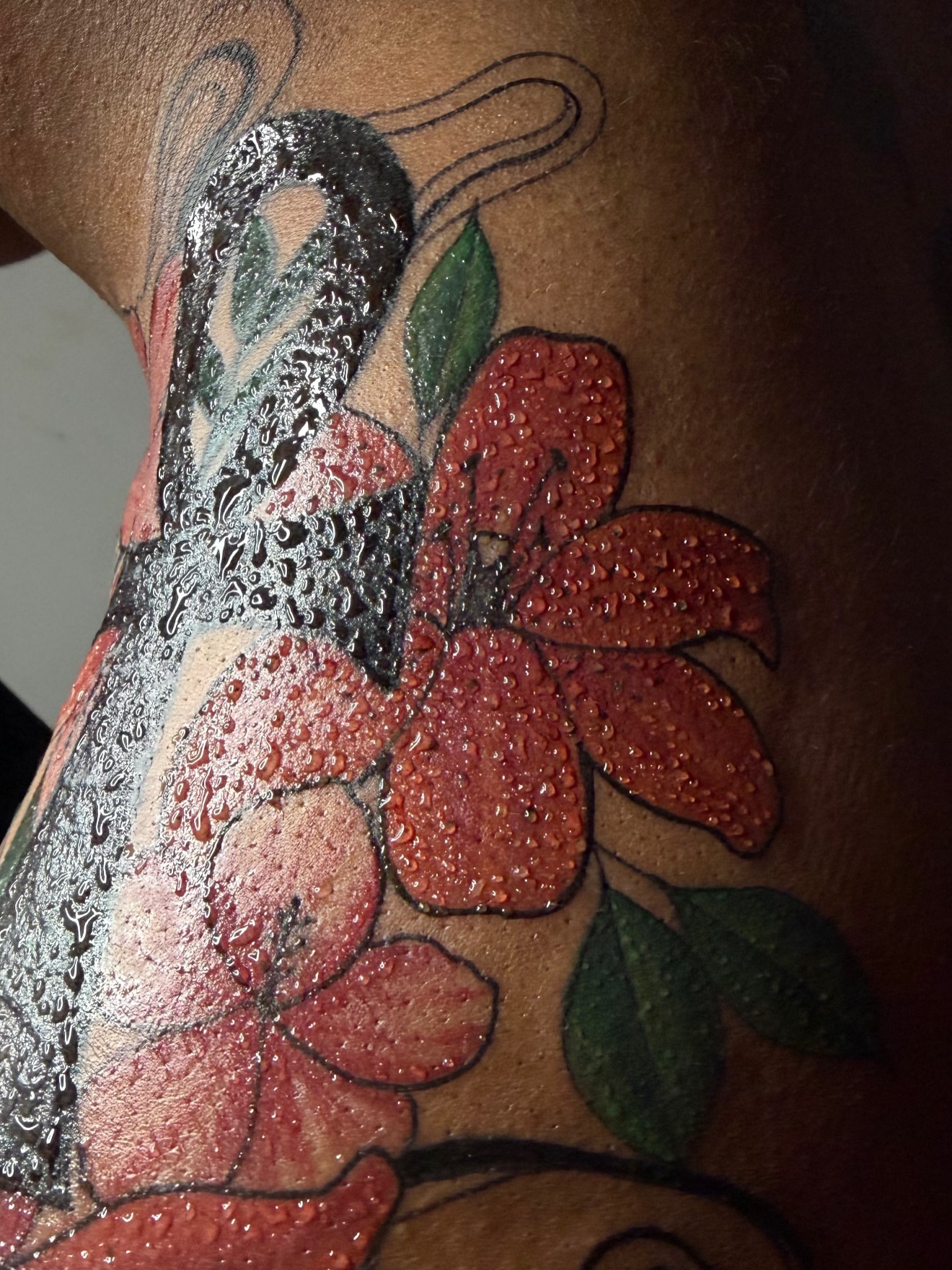 Red flowers realism tattoo on the thigh by Doll The Tattoo Artist, Addison, Texas