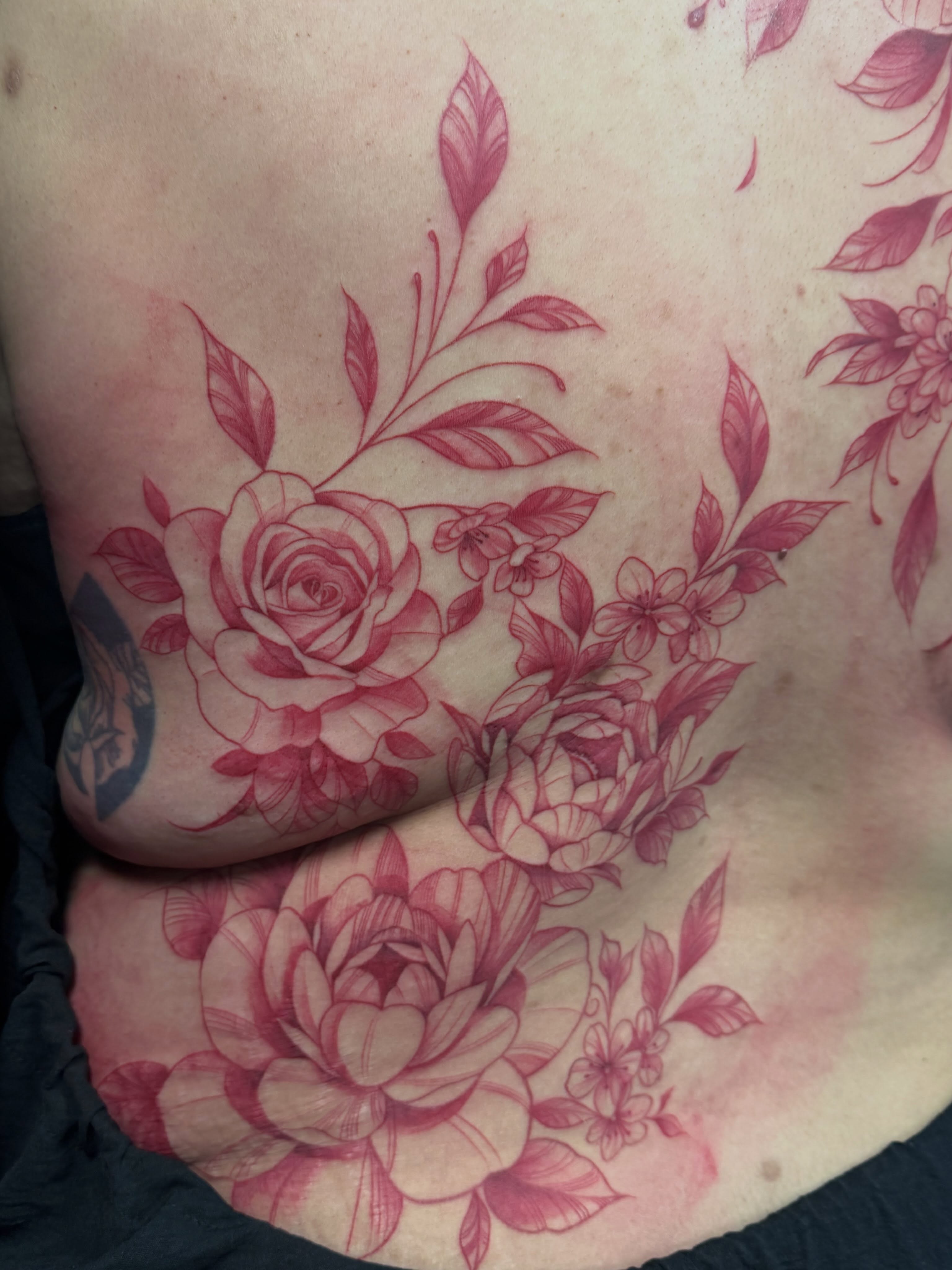 Floral bouquet fine line tattoo on the torso by Jennifer Flores