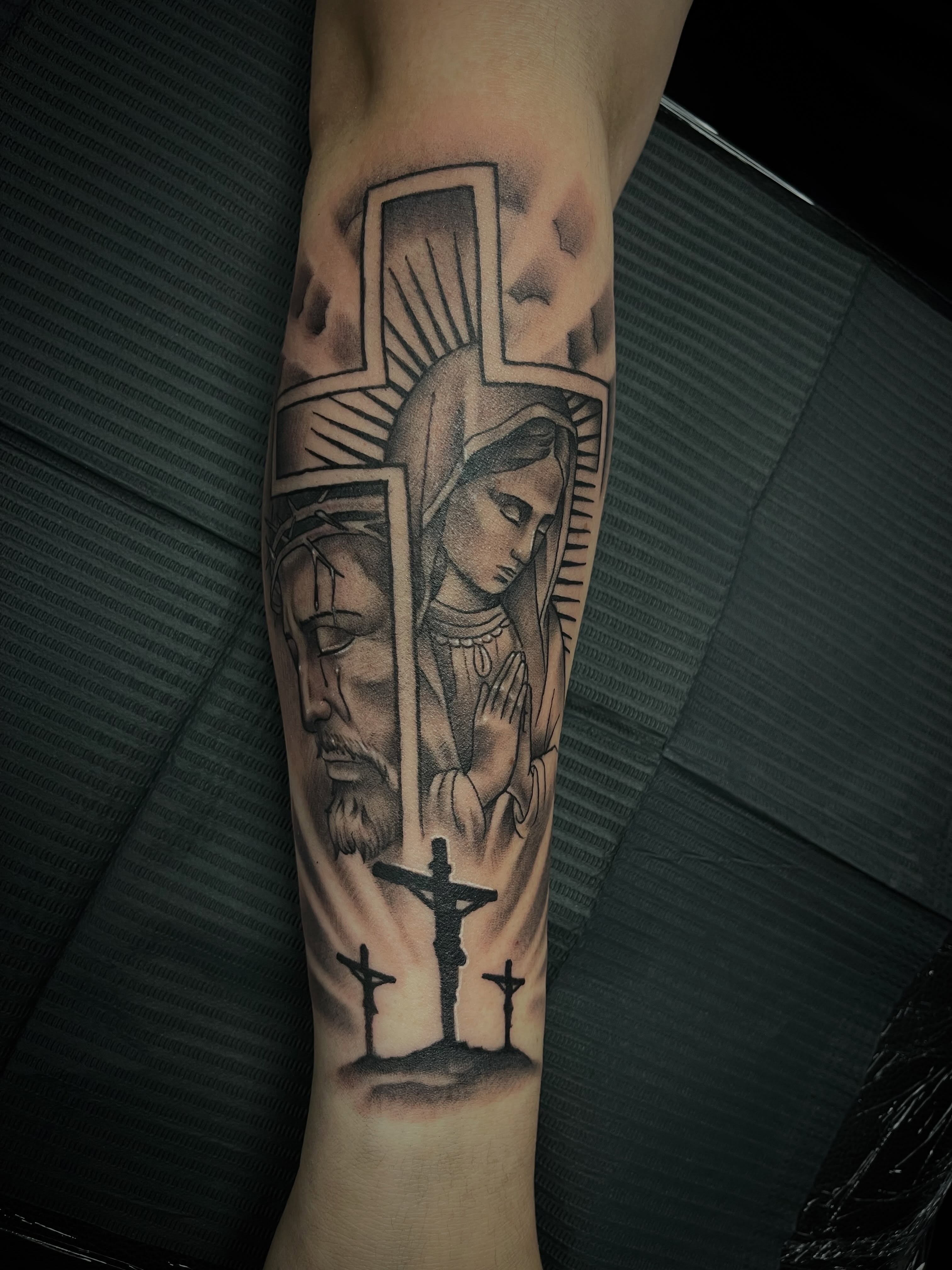 Religious iconography realism tattoo on the forearm by Chris Torres