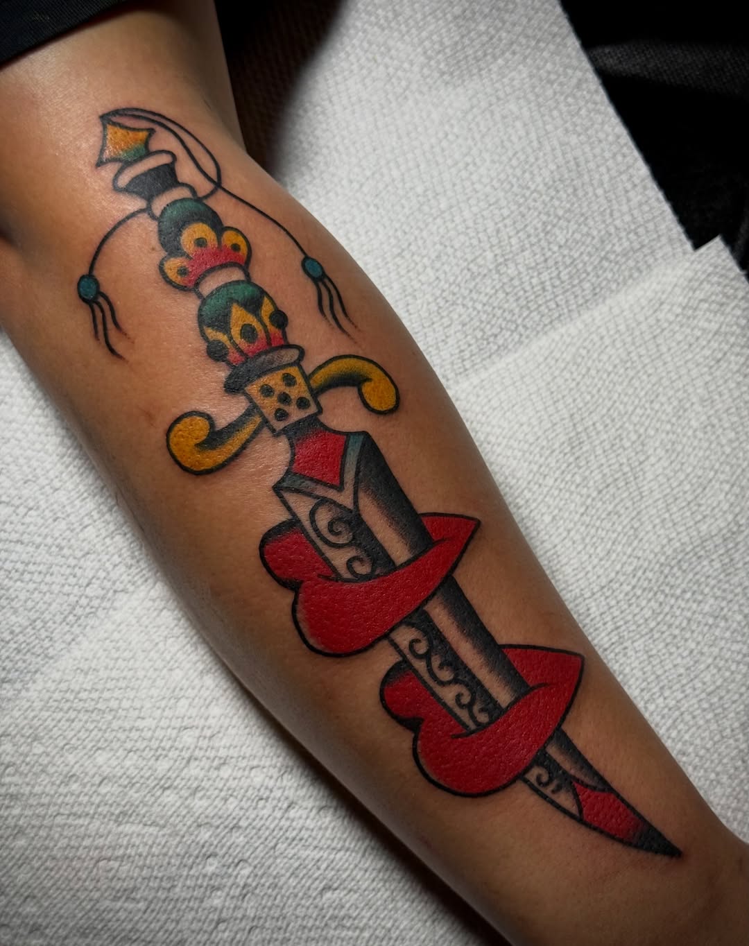 Sword and crown American traditional tattoo on the forearm by Chuck Derek Whitaker