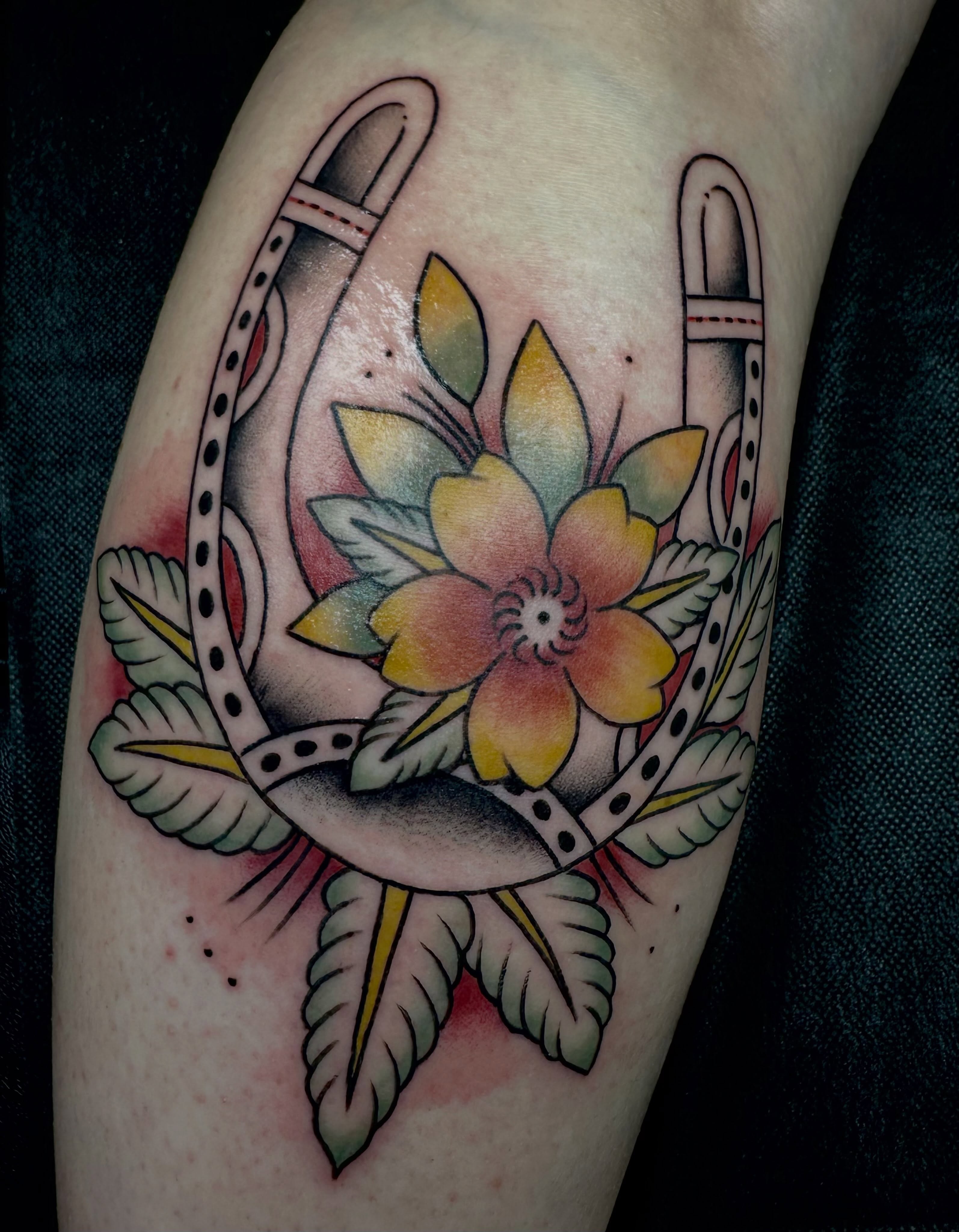 Flower and horseshoe American traditional tattoo on the forearm by emma christine