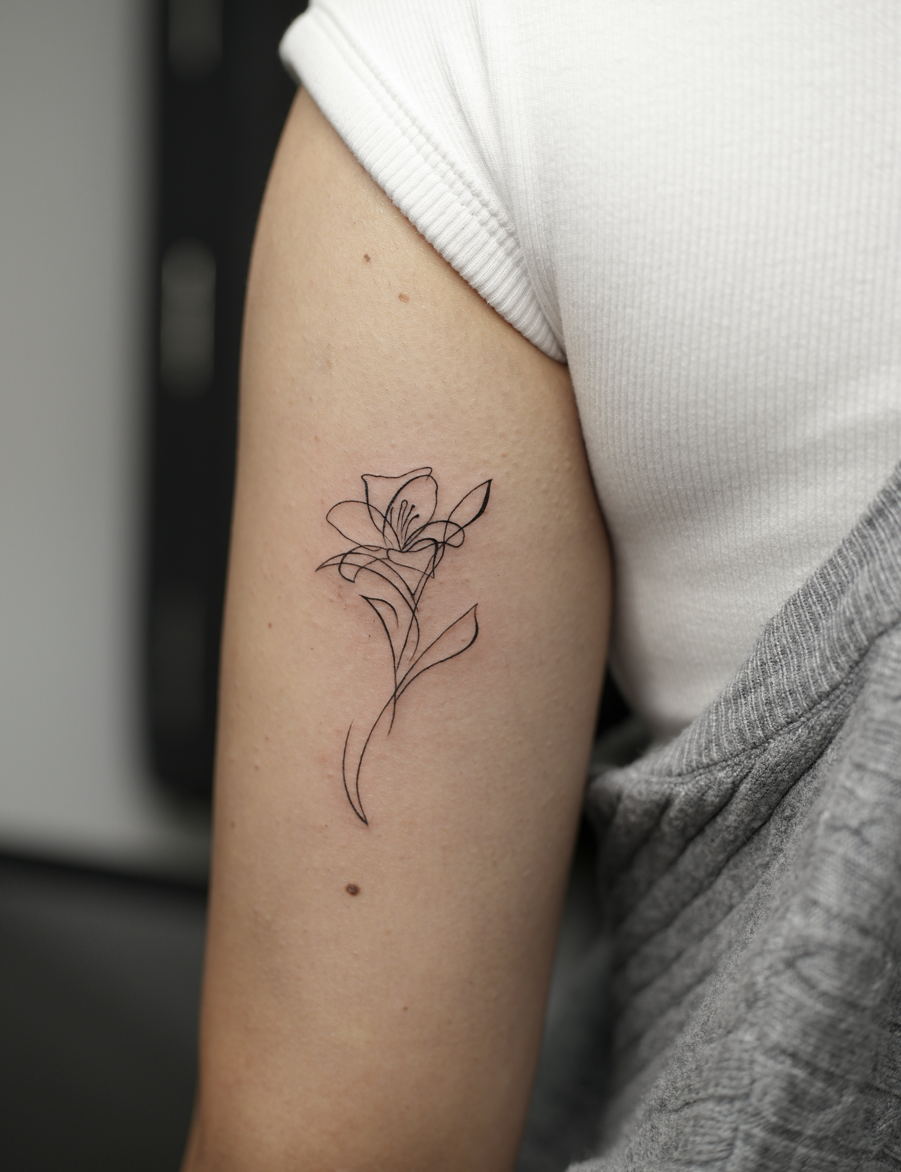 Lily fine line tattoo on the forearm by Hery Anwar