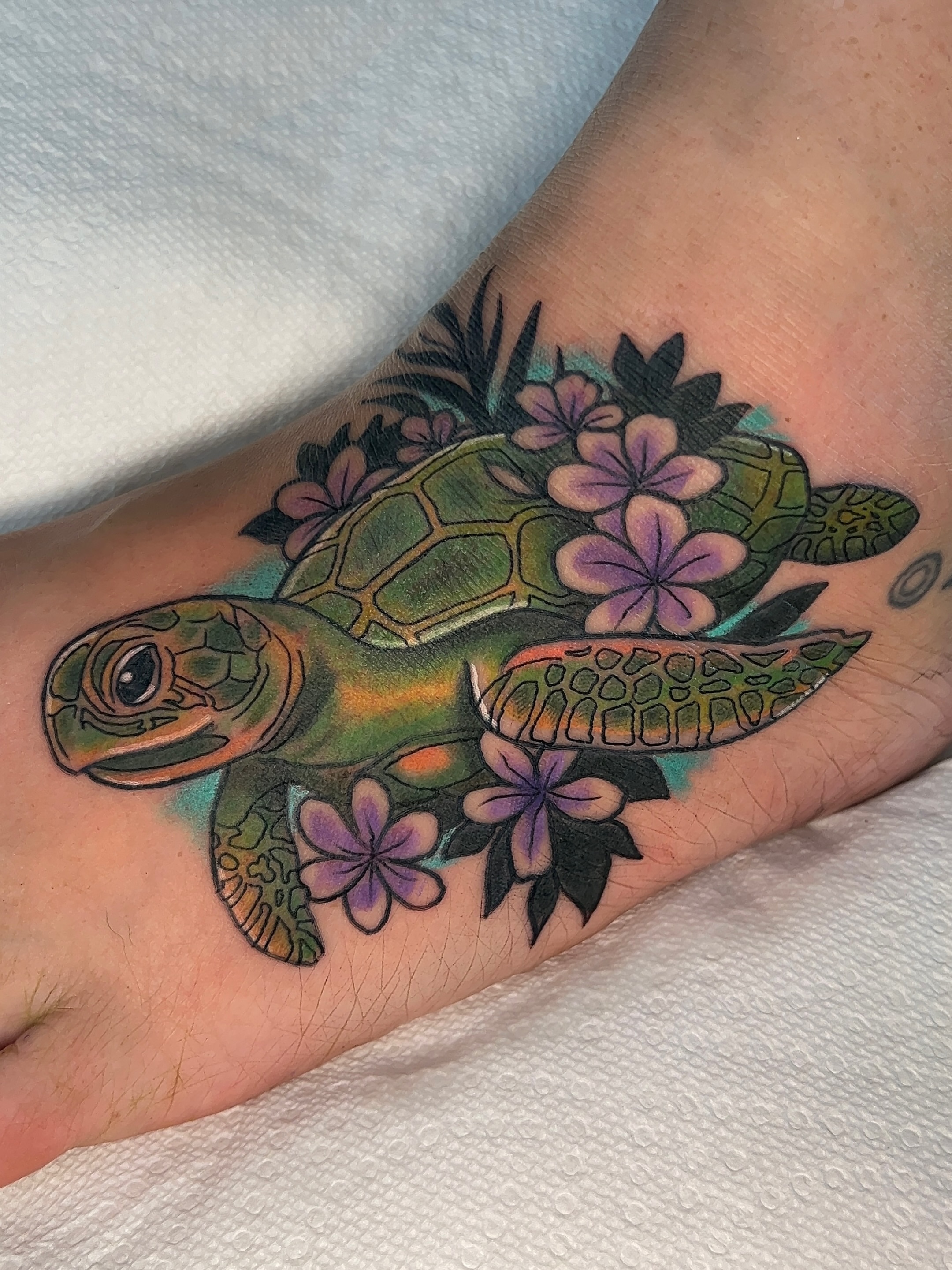 Sea turtle with flowers new school tattoo on the foot by 𝑴𝒂𝒚𝒂𖤐𝑫𝒆𝑽𝒊𝒏𝒆, Dayton, Ohio