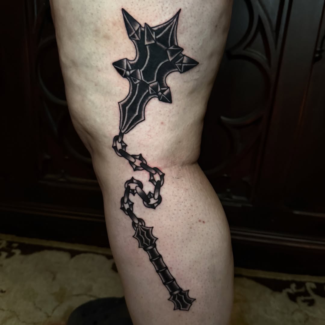 Cross and chain geometric tattoo on the thigh by Emily Lestrange