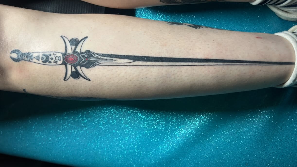 Sword black and grey tattoo on the forearm by Tattoo Kayla