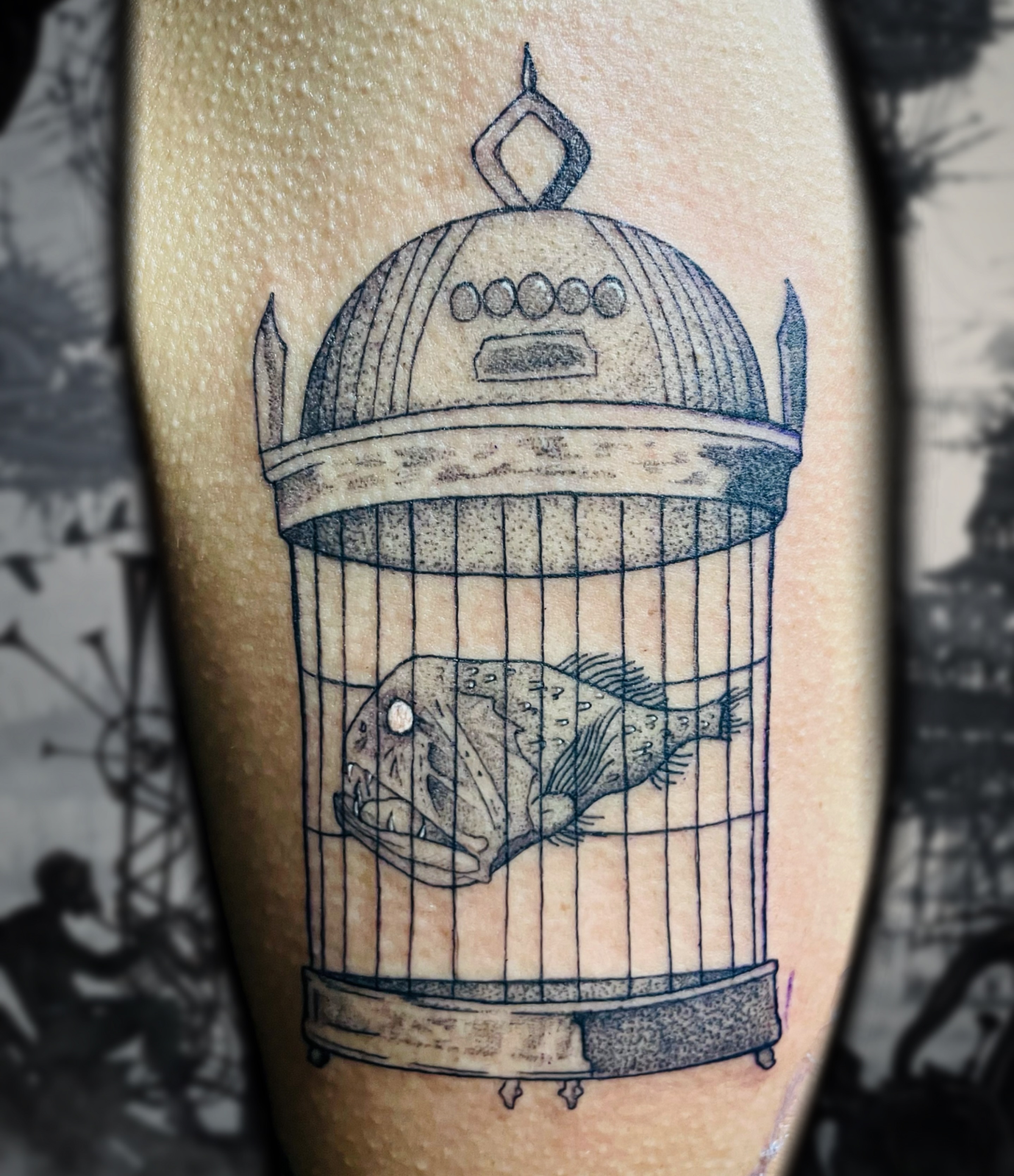 Fish in cage black and grey tattoo on the forearm by Shontel Fowler