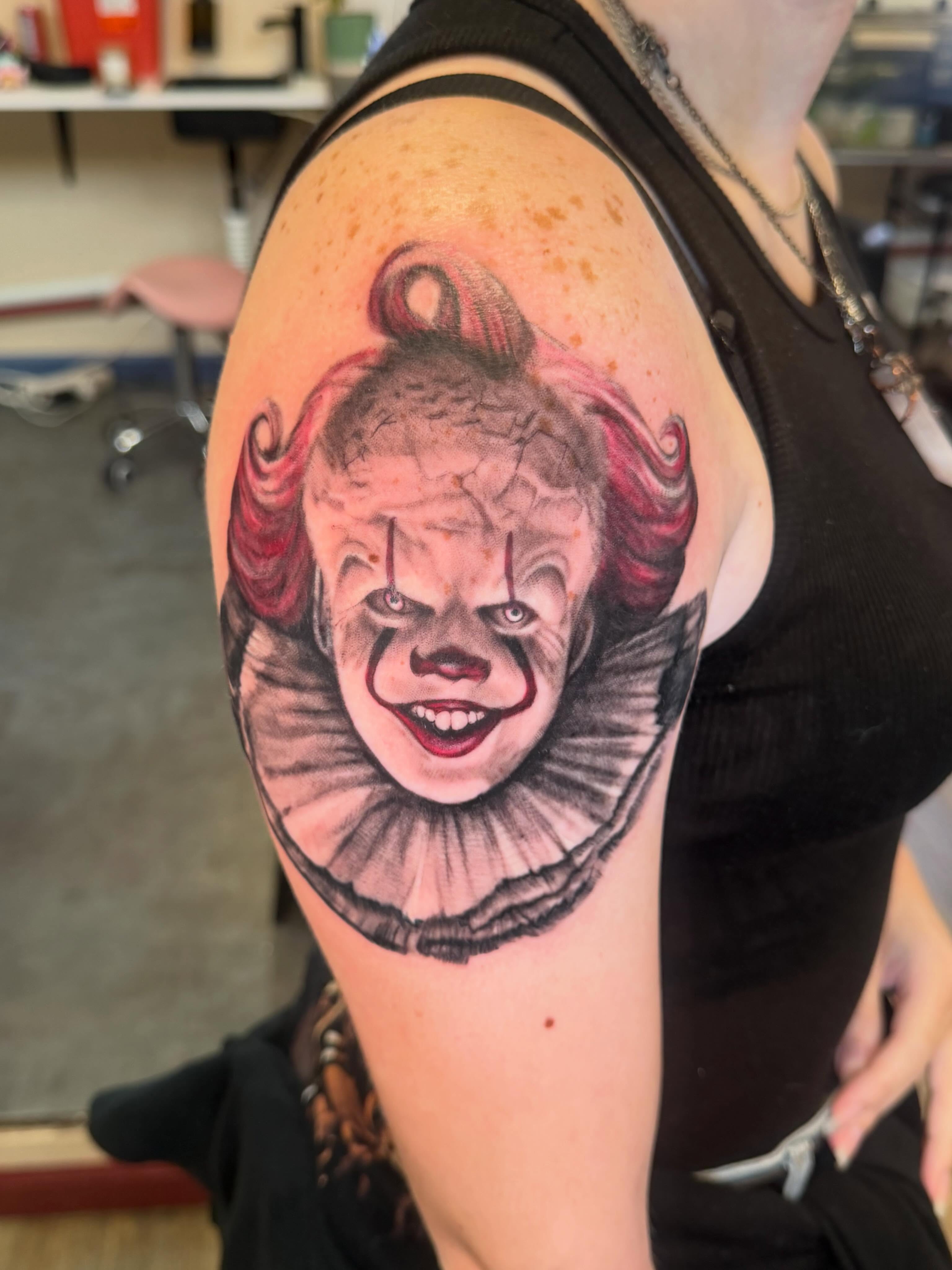 Pennywise realism tattoo on the shoulder by Hatchetfoot Art