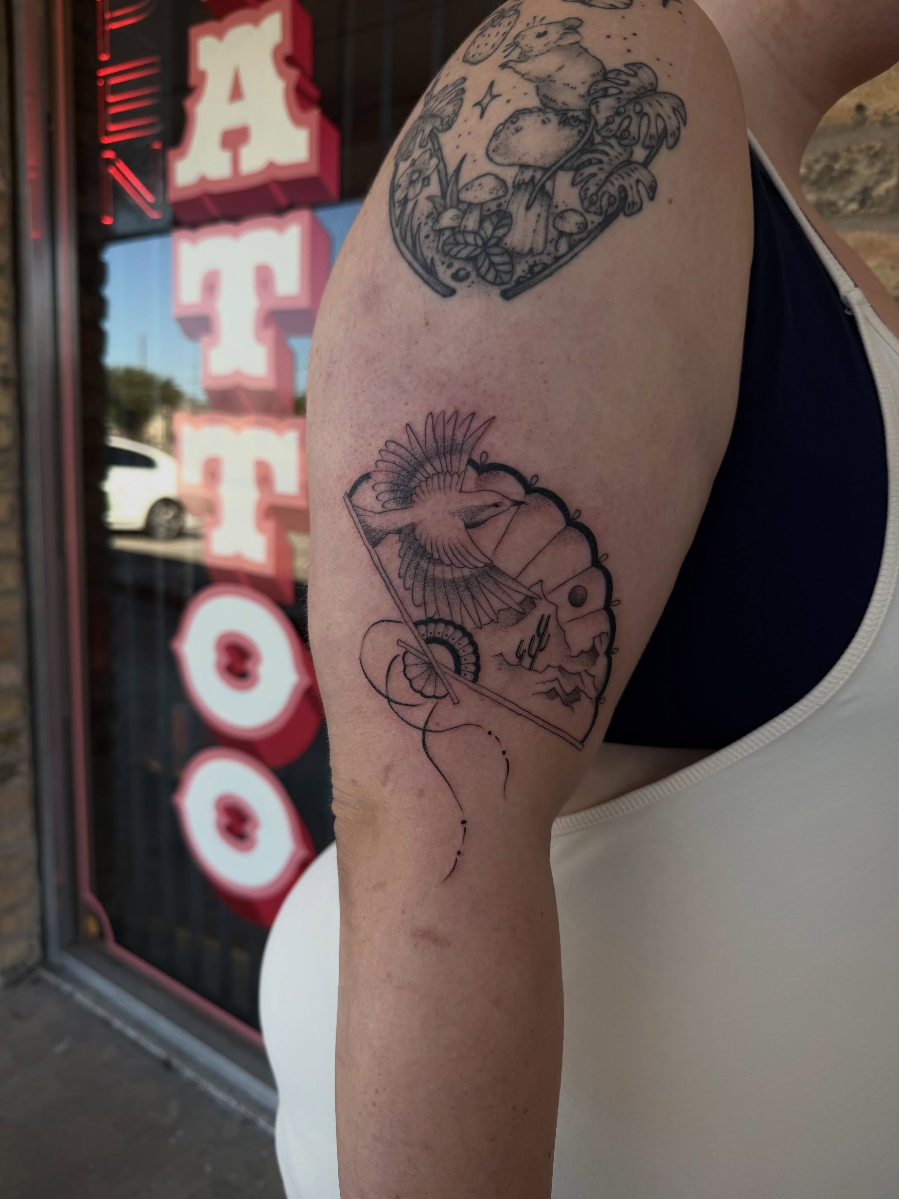 Bird and fan American traditional tattoo on the upper arm by christian martinez