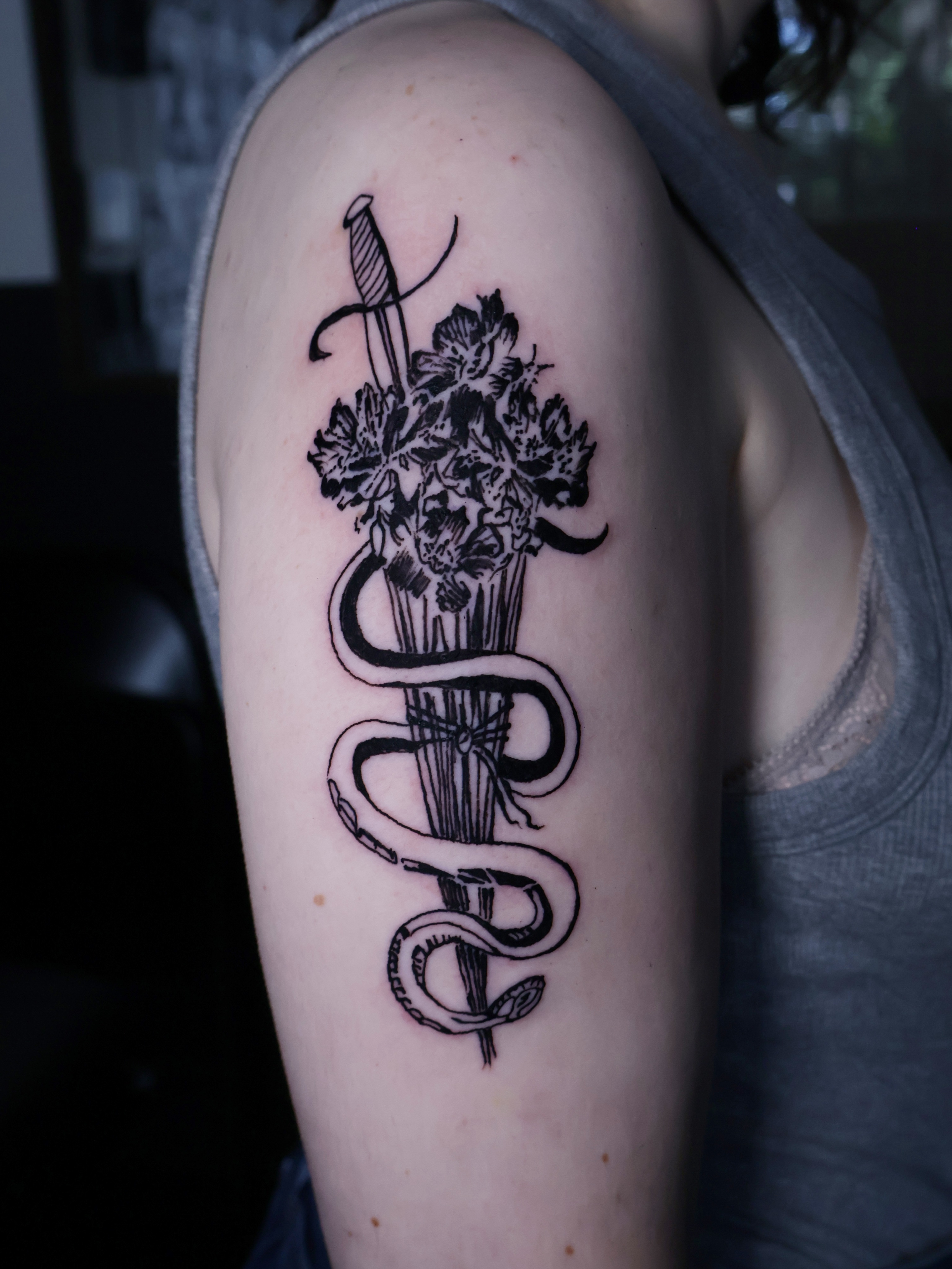 Flowers and snake black and grey tattoo on the upper arm by Denis Du Preez, East Williamsburg, Brooklyn