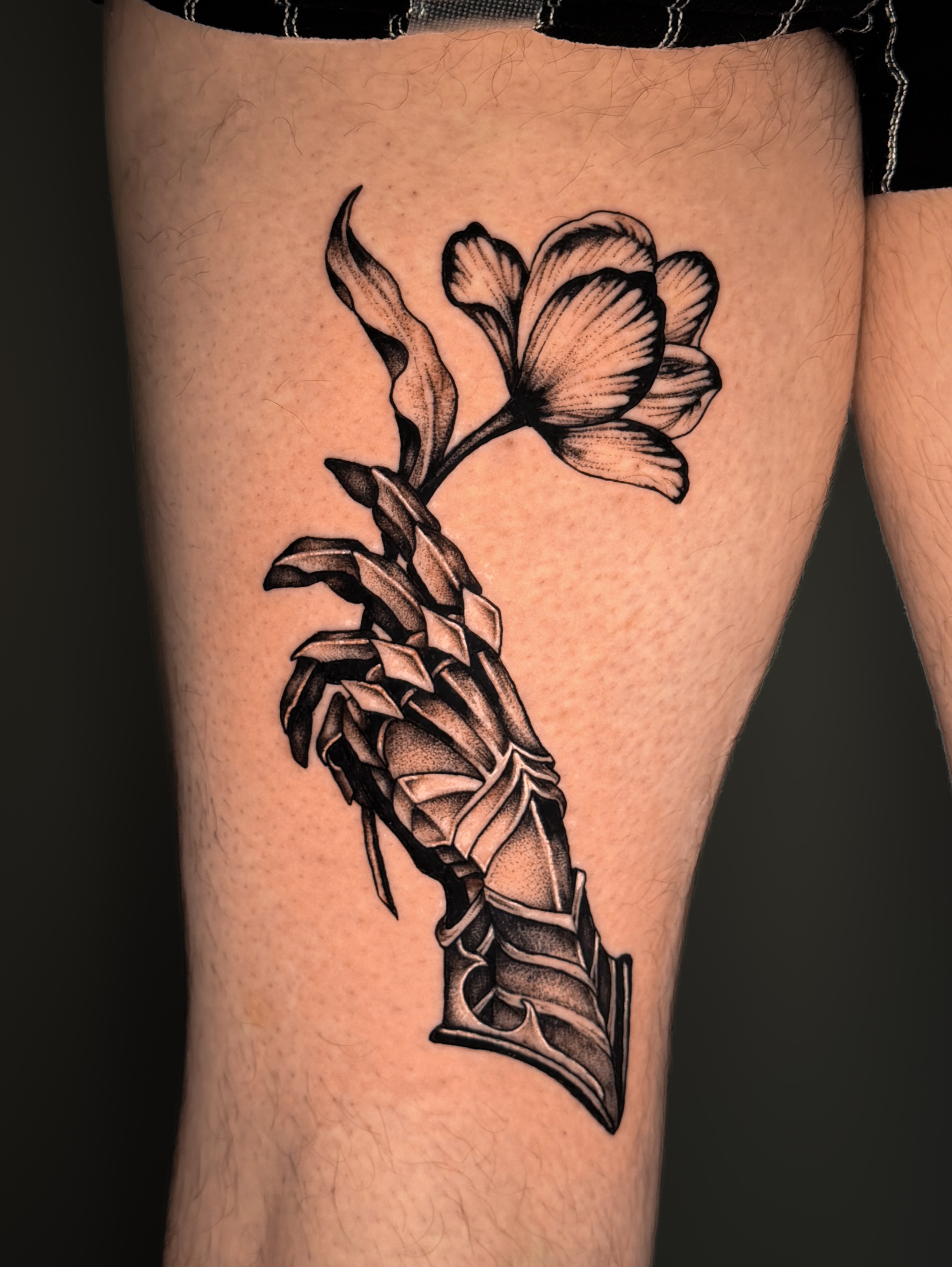 Flower and dagger dotwork tattoo on the thigh by Kam Mills