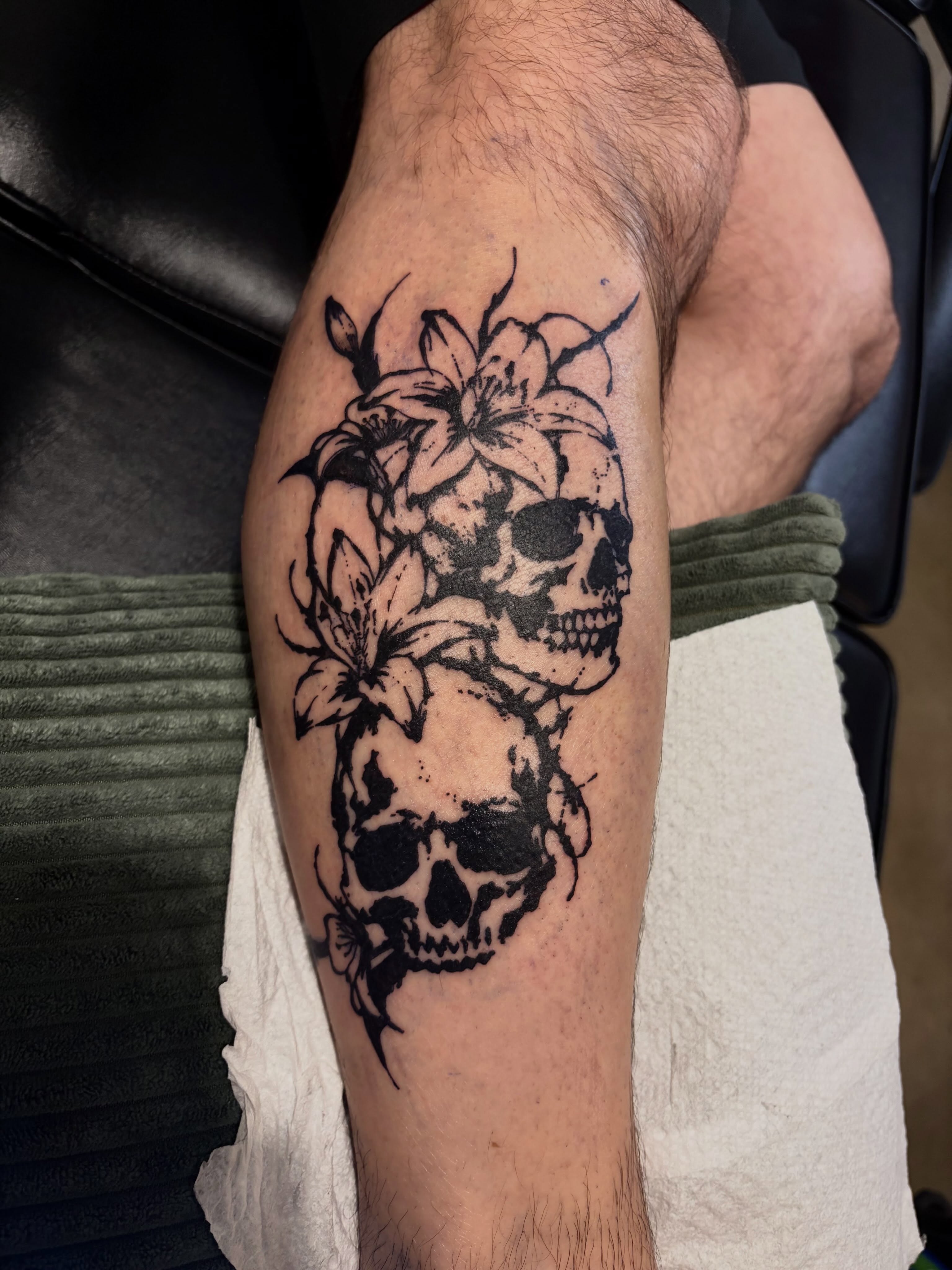 Skulls and lilies black and grey tattoo on the forearm by blastedbybk