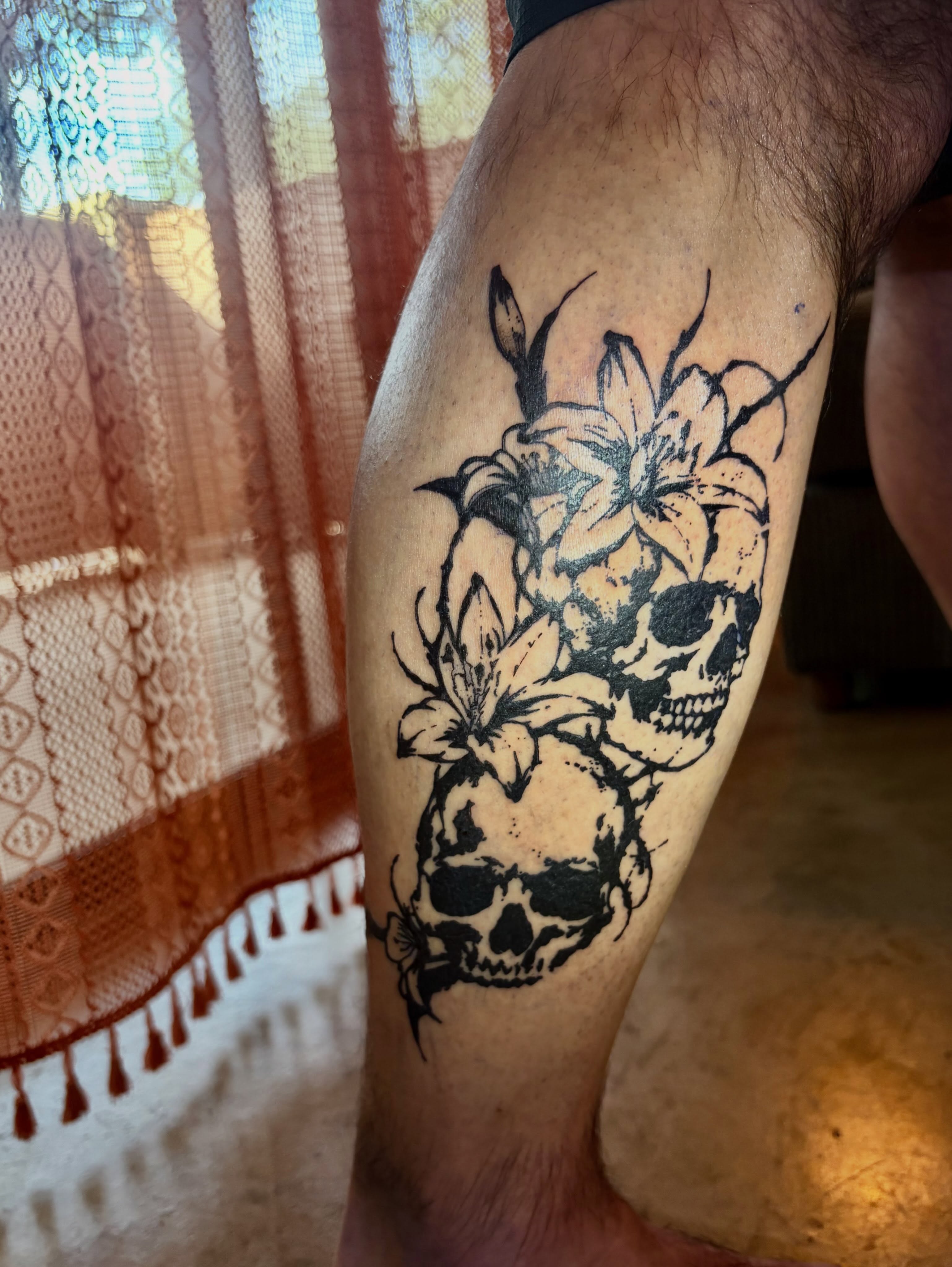 Skulls and lilies black and grey tattoo on the thigh by blastedbybk