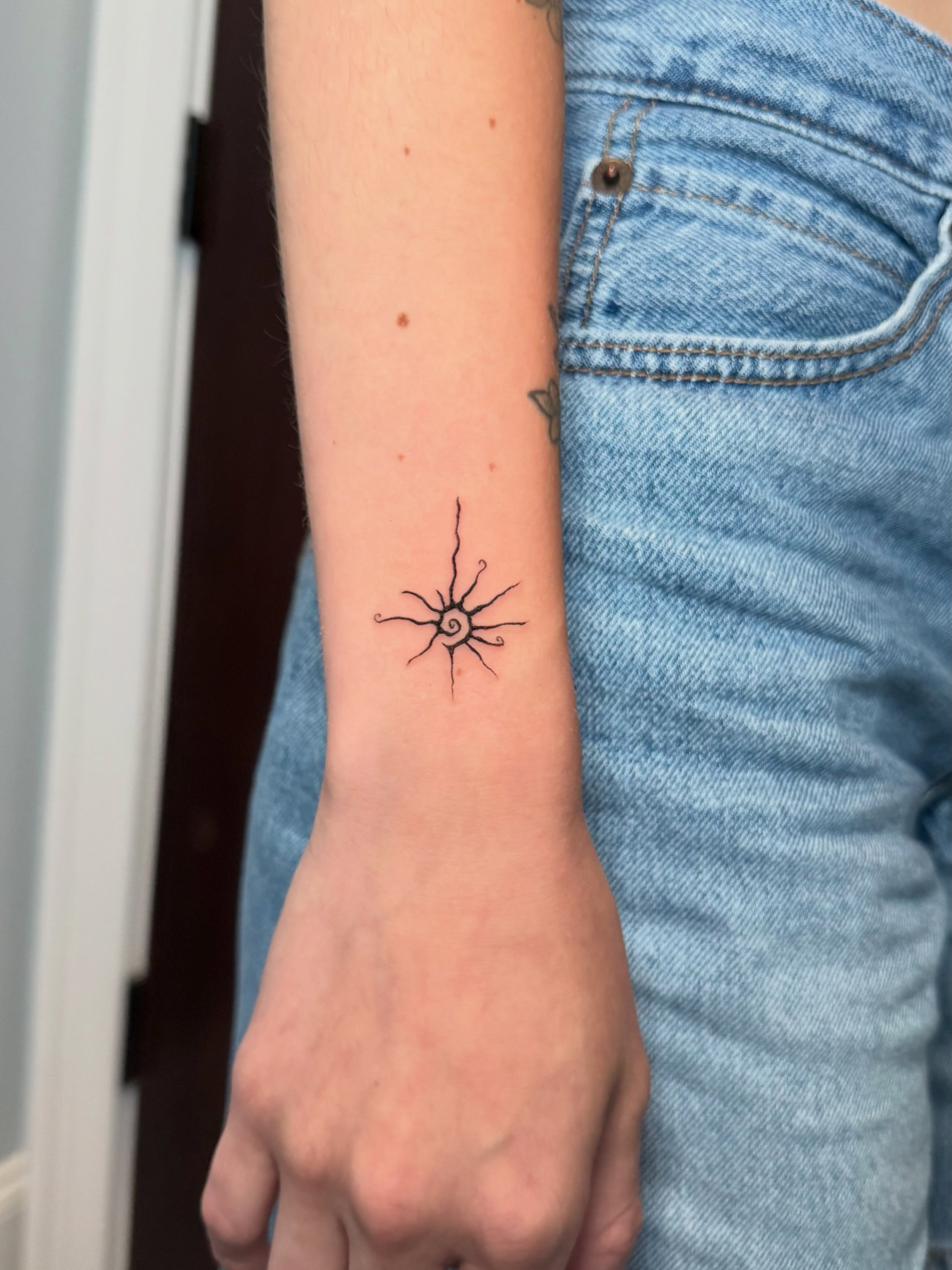 Sunburst geometric tattoo on the forearm by Ana Blatt