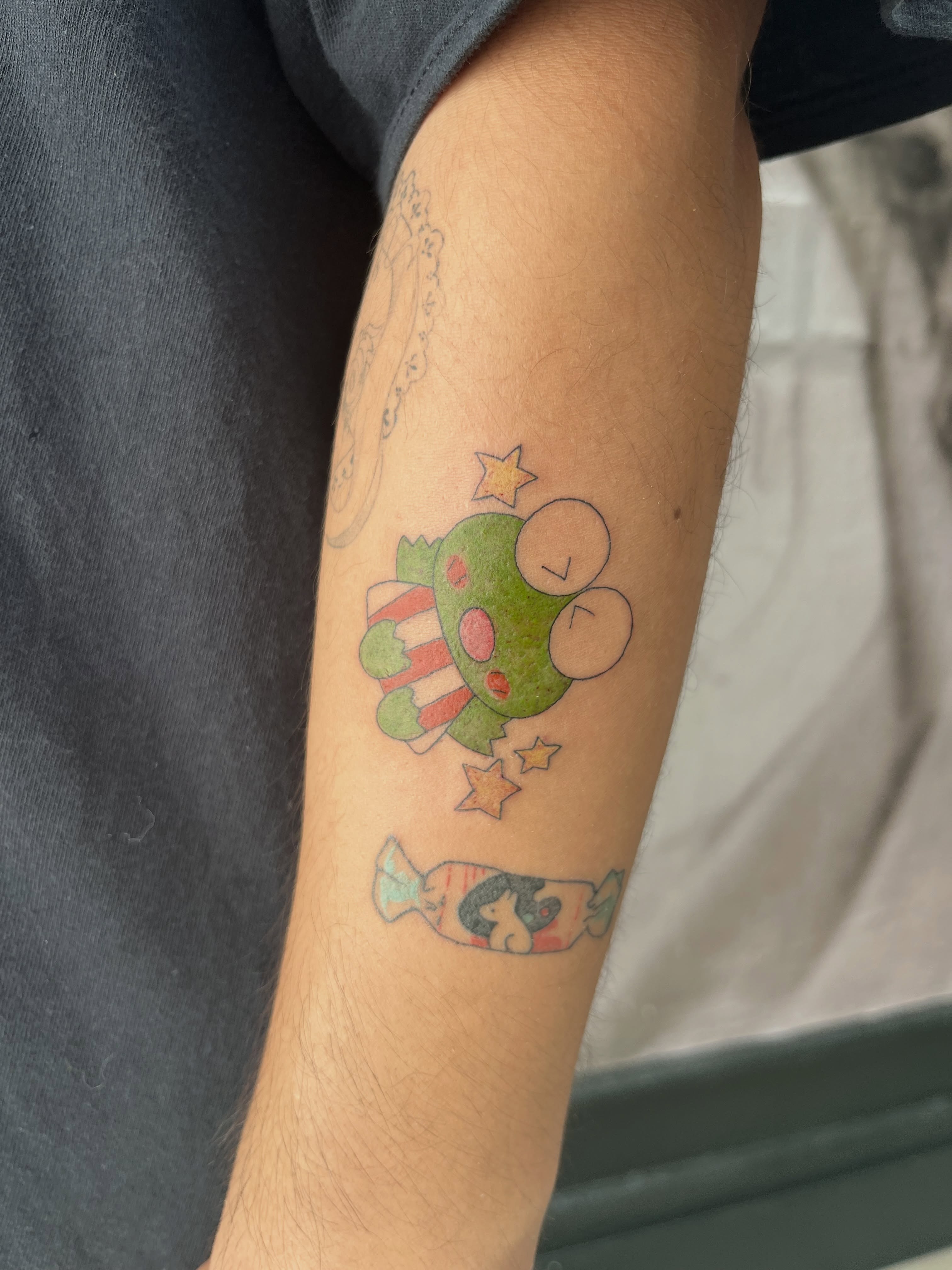 Kawaii frog dotwork tattoo on the forearm by Kyra Monterrosa
