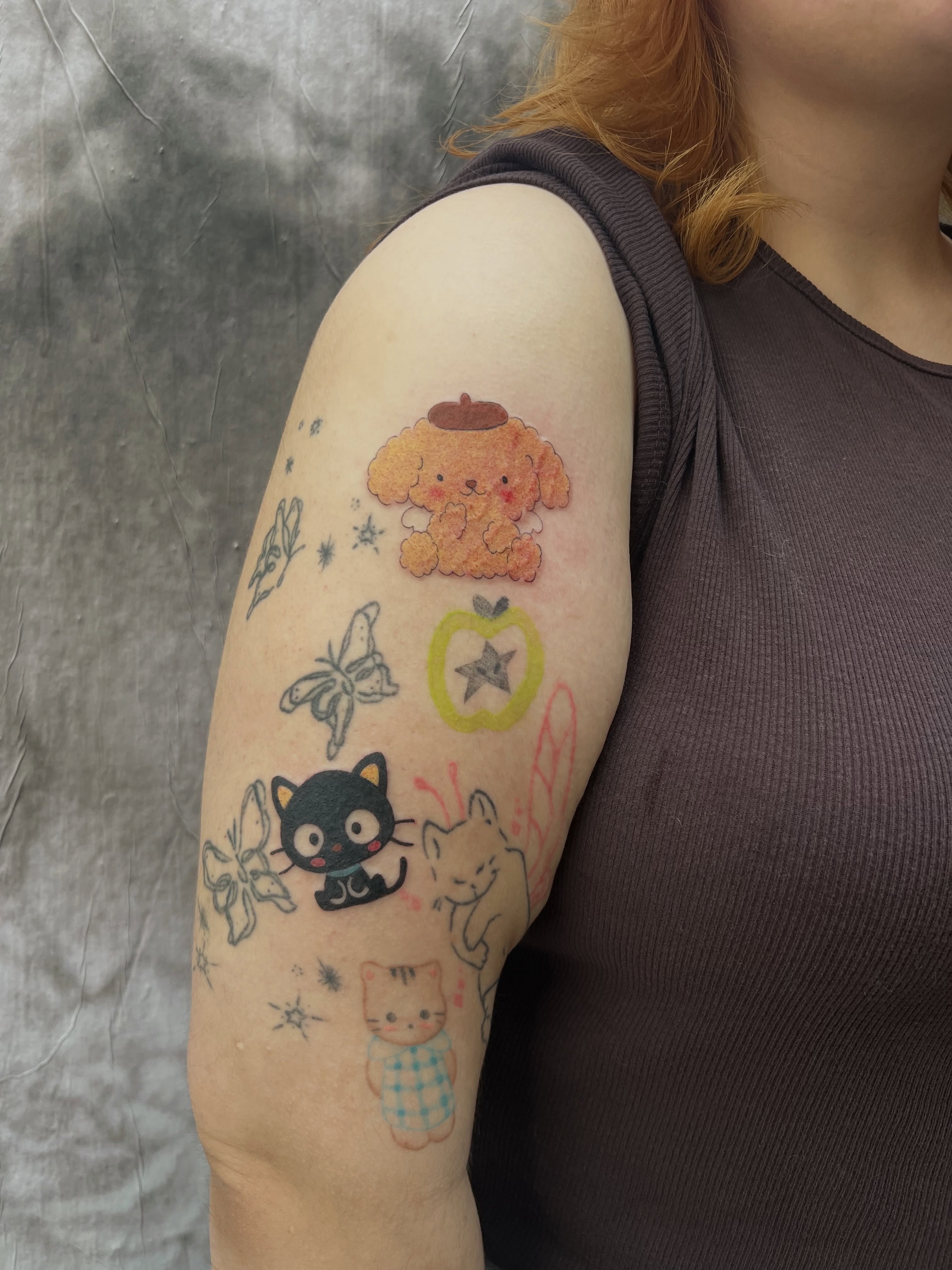 Kawaii characters illustrative tattoo on the upper arm by Kyra Monterrosa