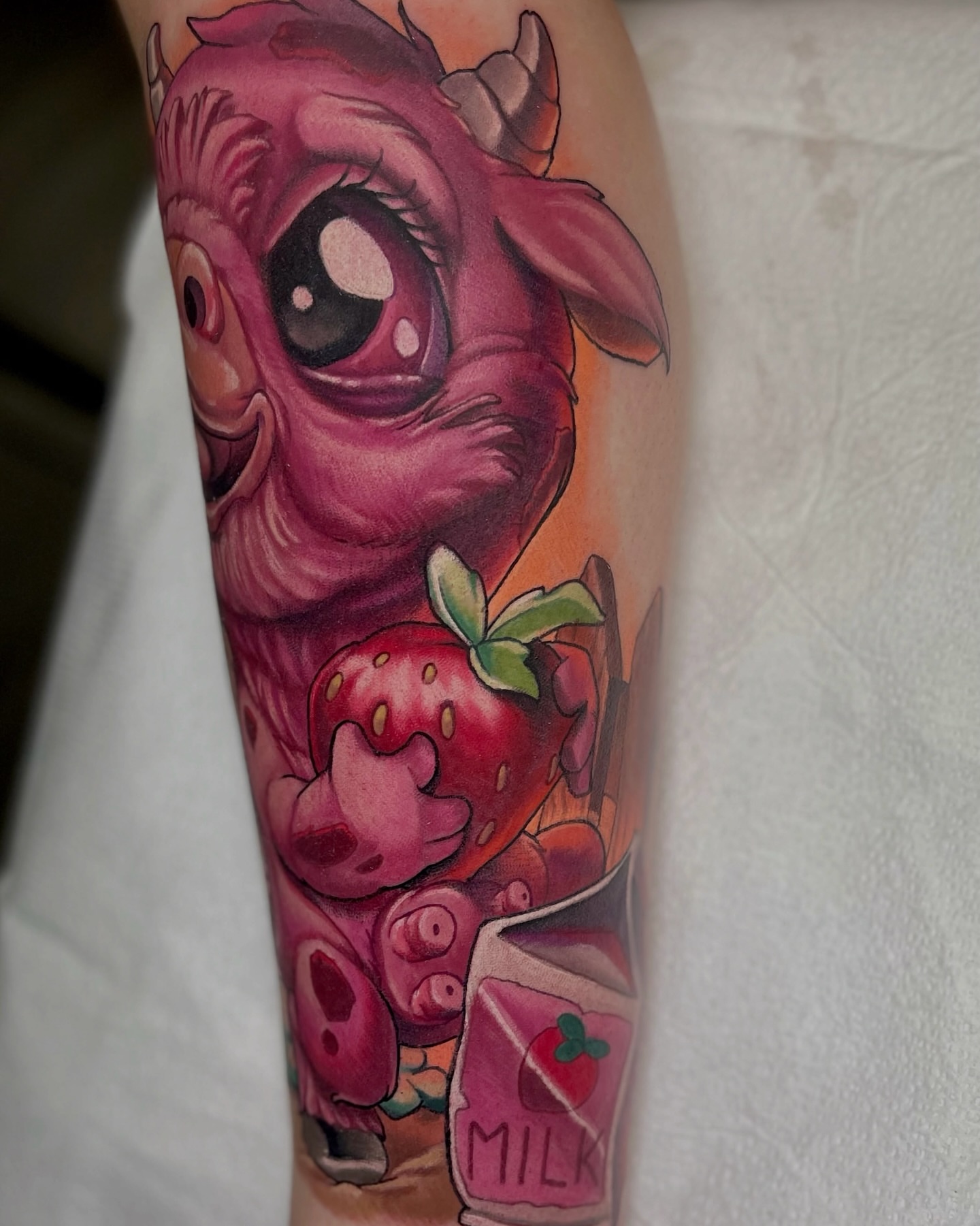 Strawberry and cow realism tattoo on the forearm by Jacob Webb