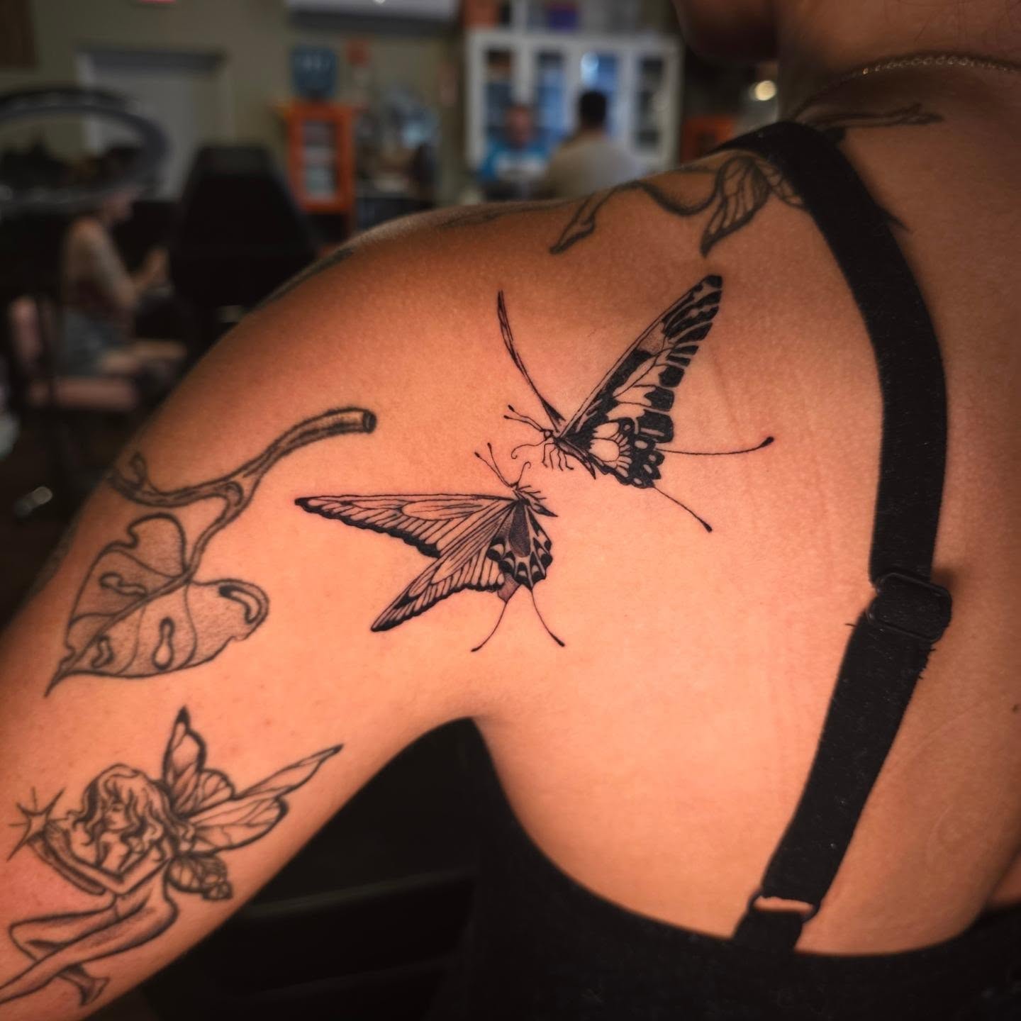 Butterflies and fairy black and grey tattoo on the shoulder by Maggie
