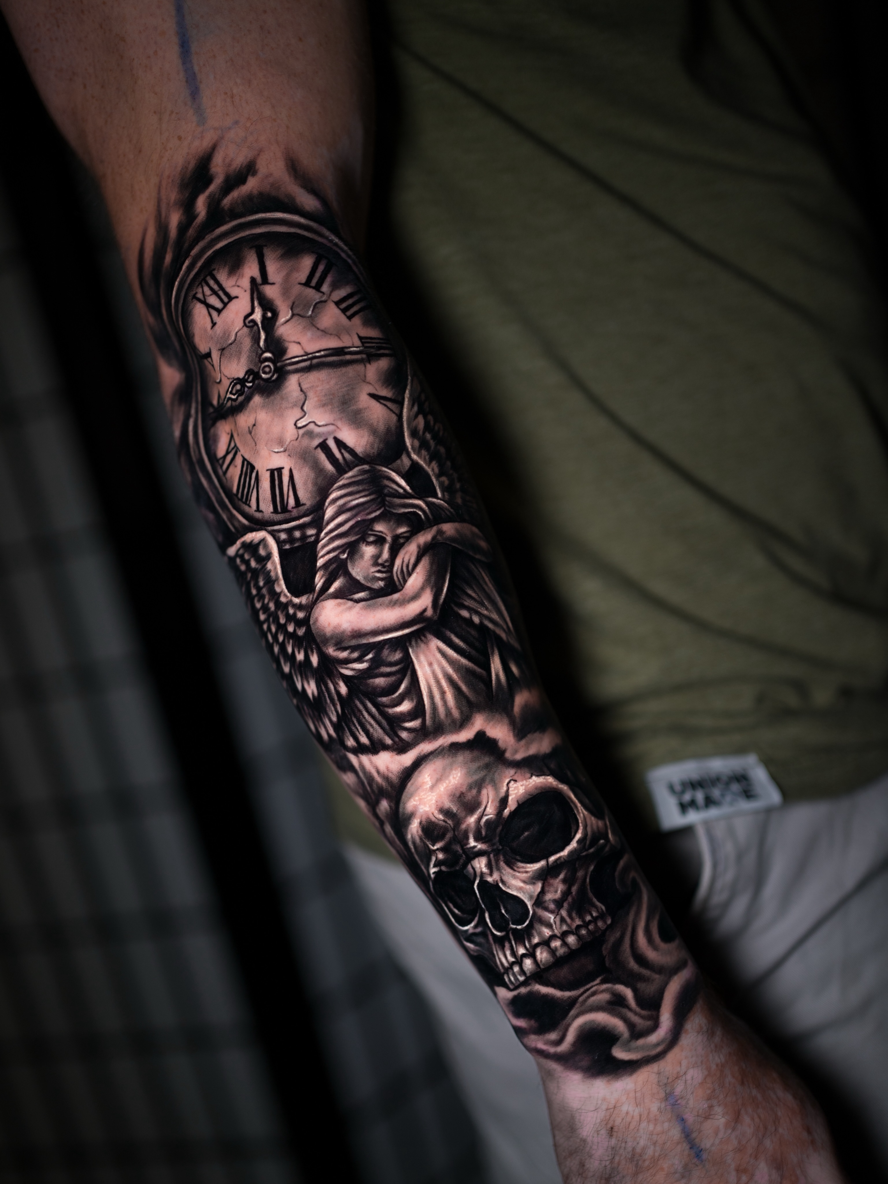 Clock and angel realism tattoo on the forearm by Juan David Arias