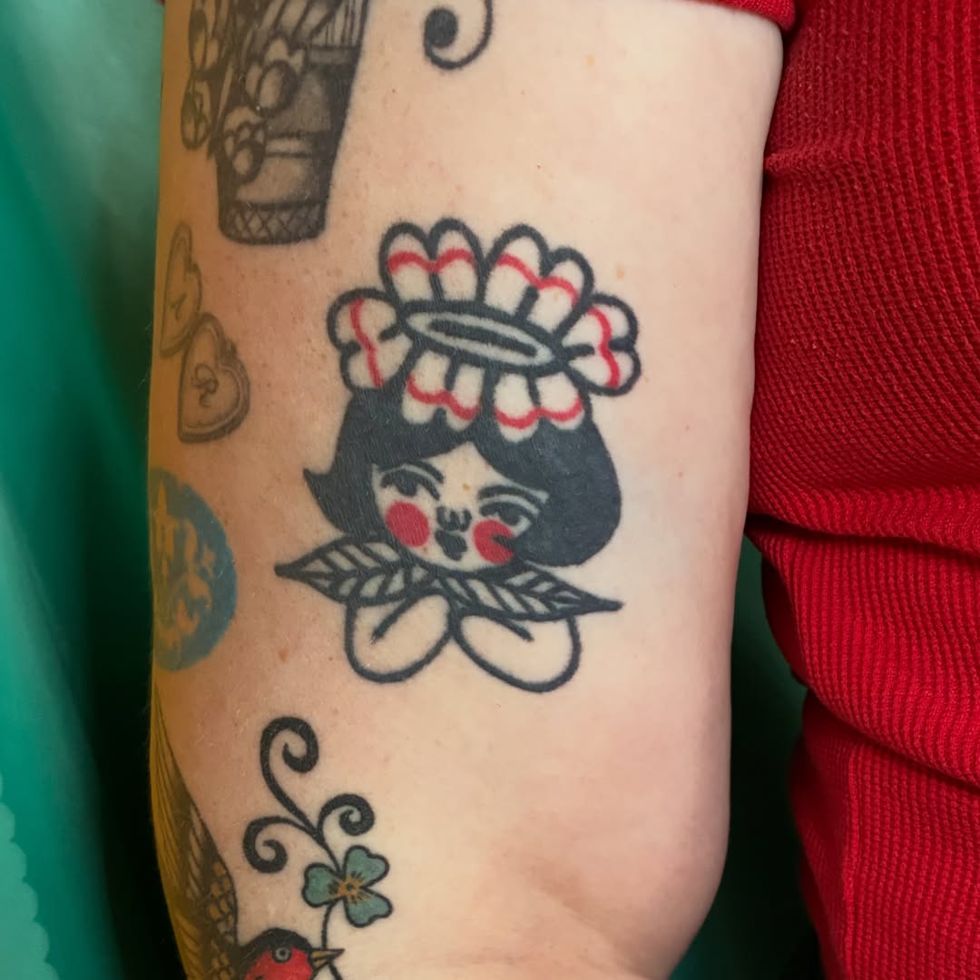Doll with flower crown American traditional tattoo on the forearm by Kaily McKee