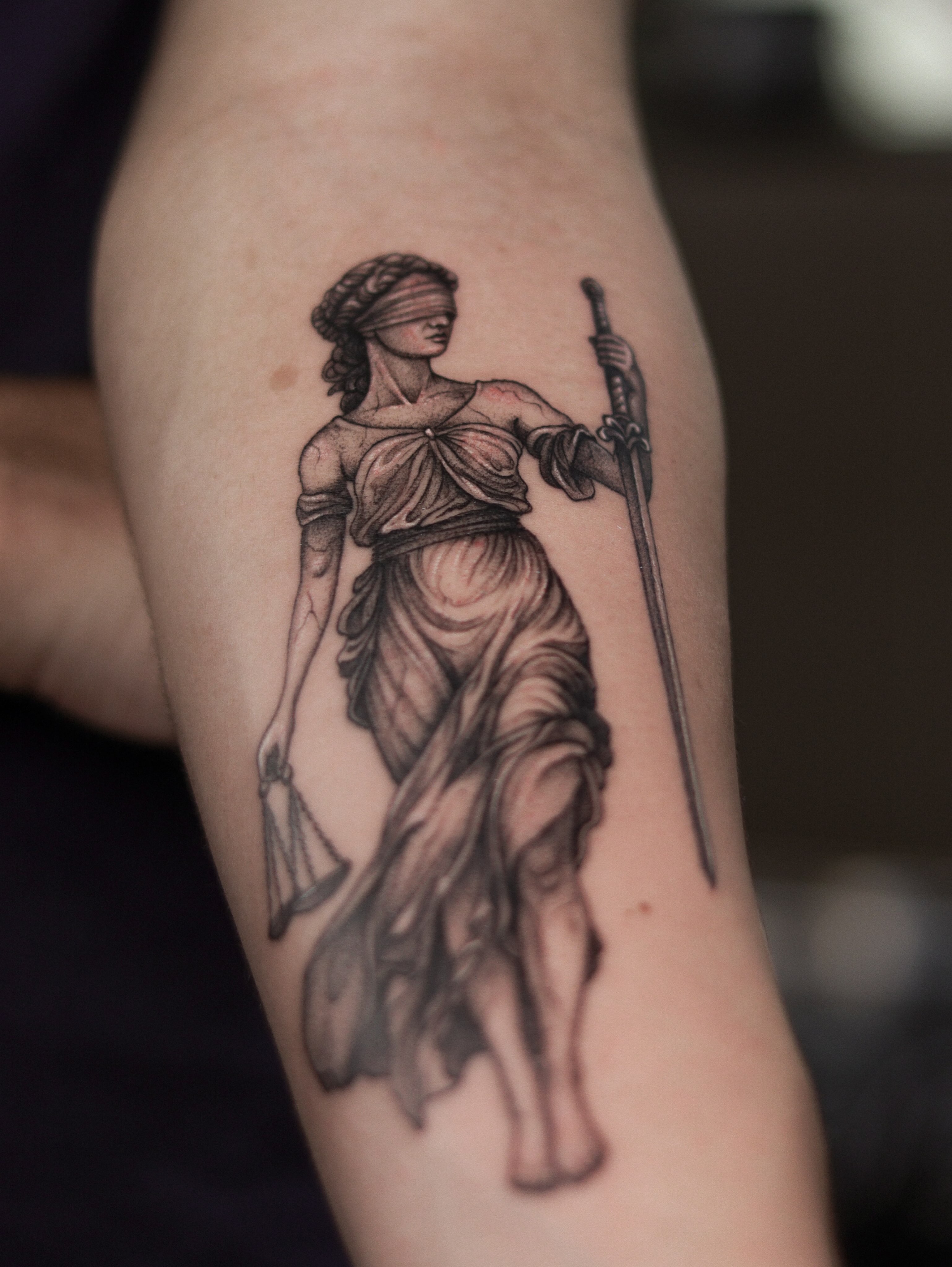Justice statue black and grey tattoo on the forearm by Arthur Kossoski