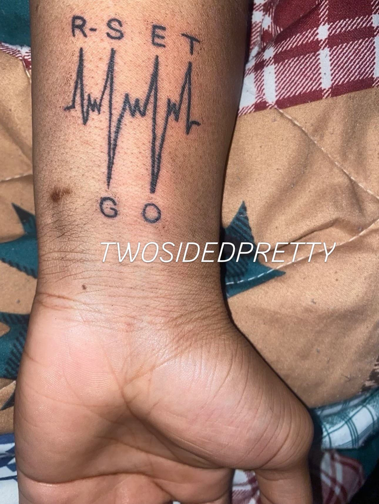 Reset go lettering script tattoo on the forearm by @twosidedpretty