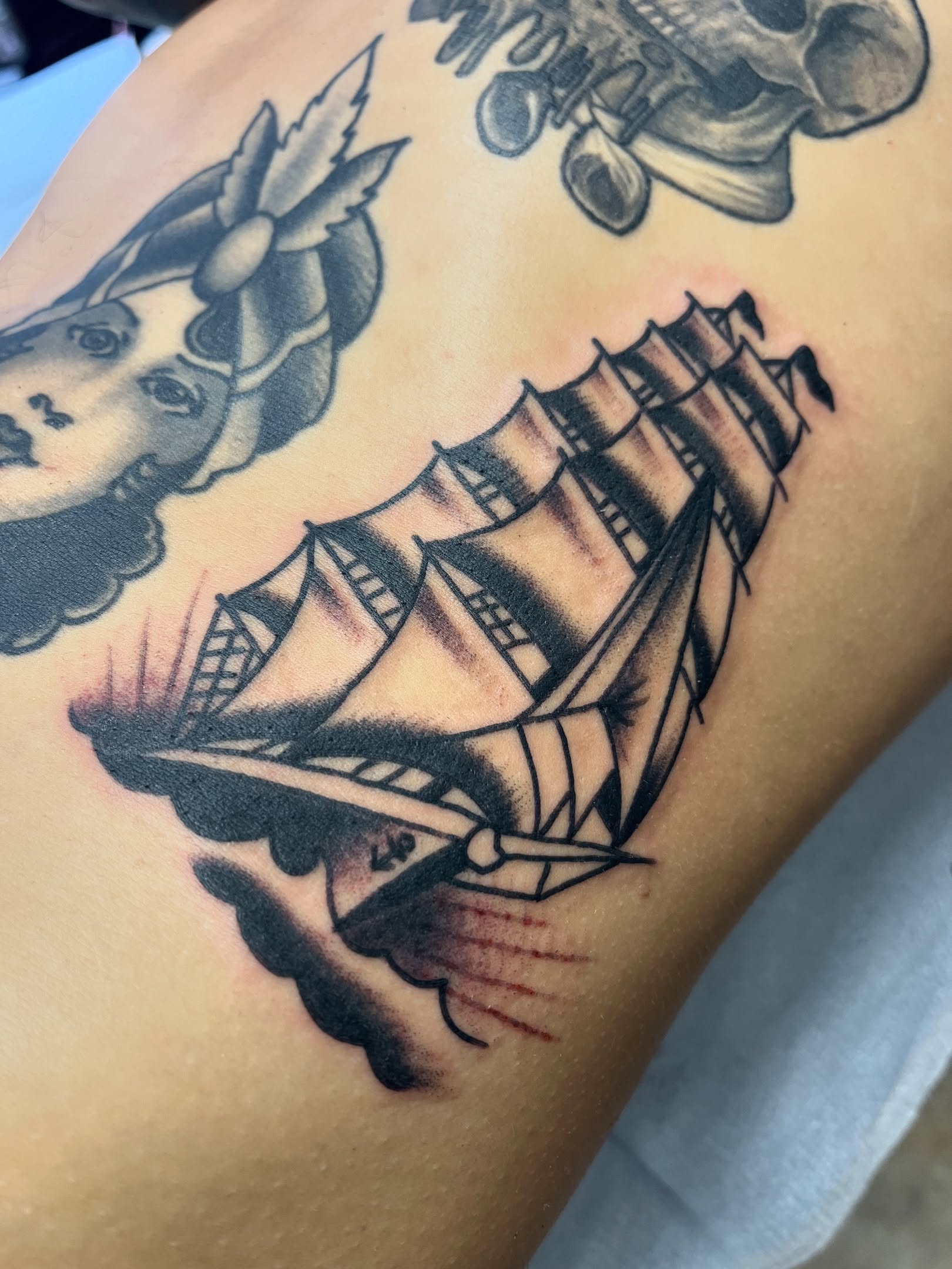 Ship American traditional tattoo on the upper arm by Tim Howell