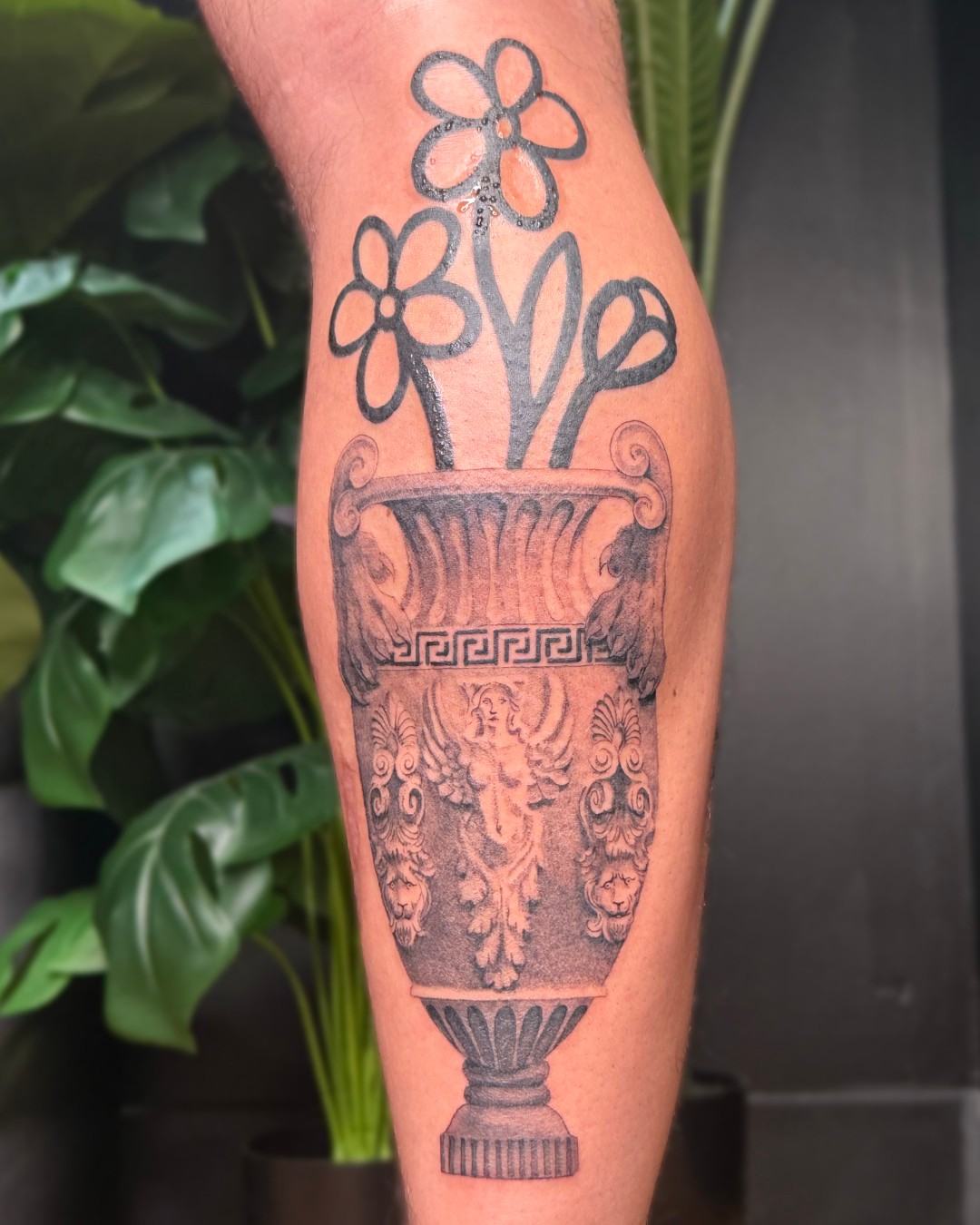 Urn with flowers black and grey tattoo on the forearm by Erin Isaacs