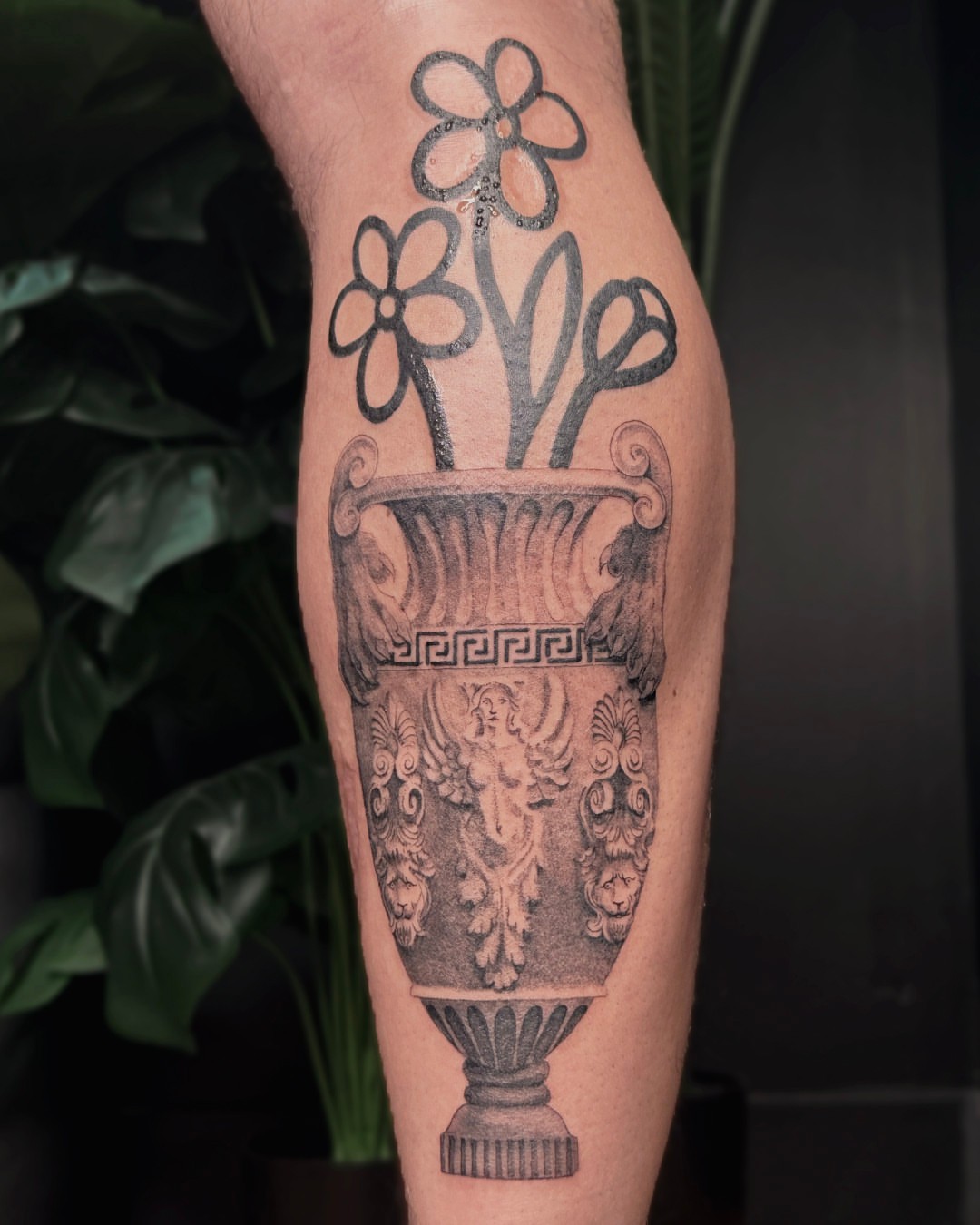 Ancient vase with flowers black and grey tattoo on the forearm by Erin Isaacs