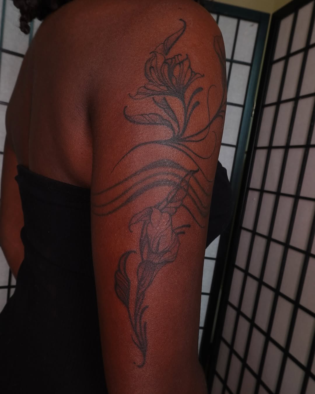 Floral design black and grey tattoo on the upper arm by jun