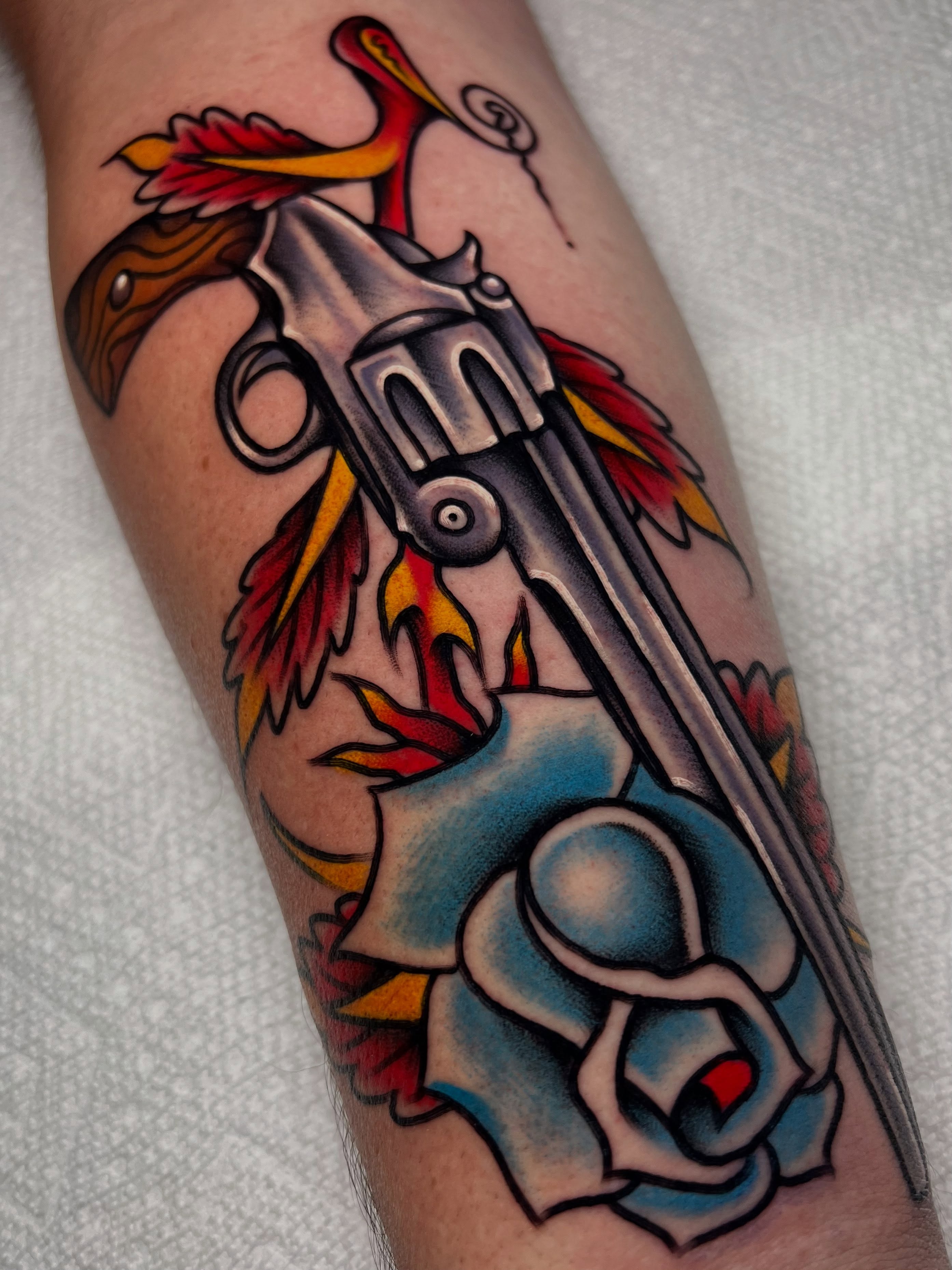 Revolver and phoenix American traditional tattoo on the forearm by ᴍᴀᴛᴛ ᴀʟᴇxᴀɴᴅᴇʀ