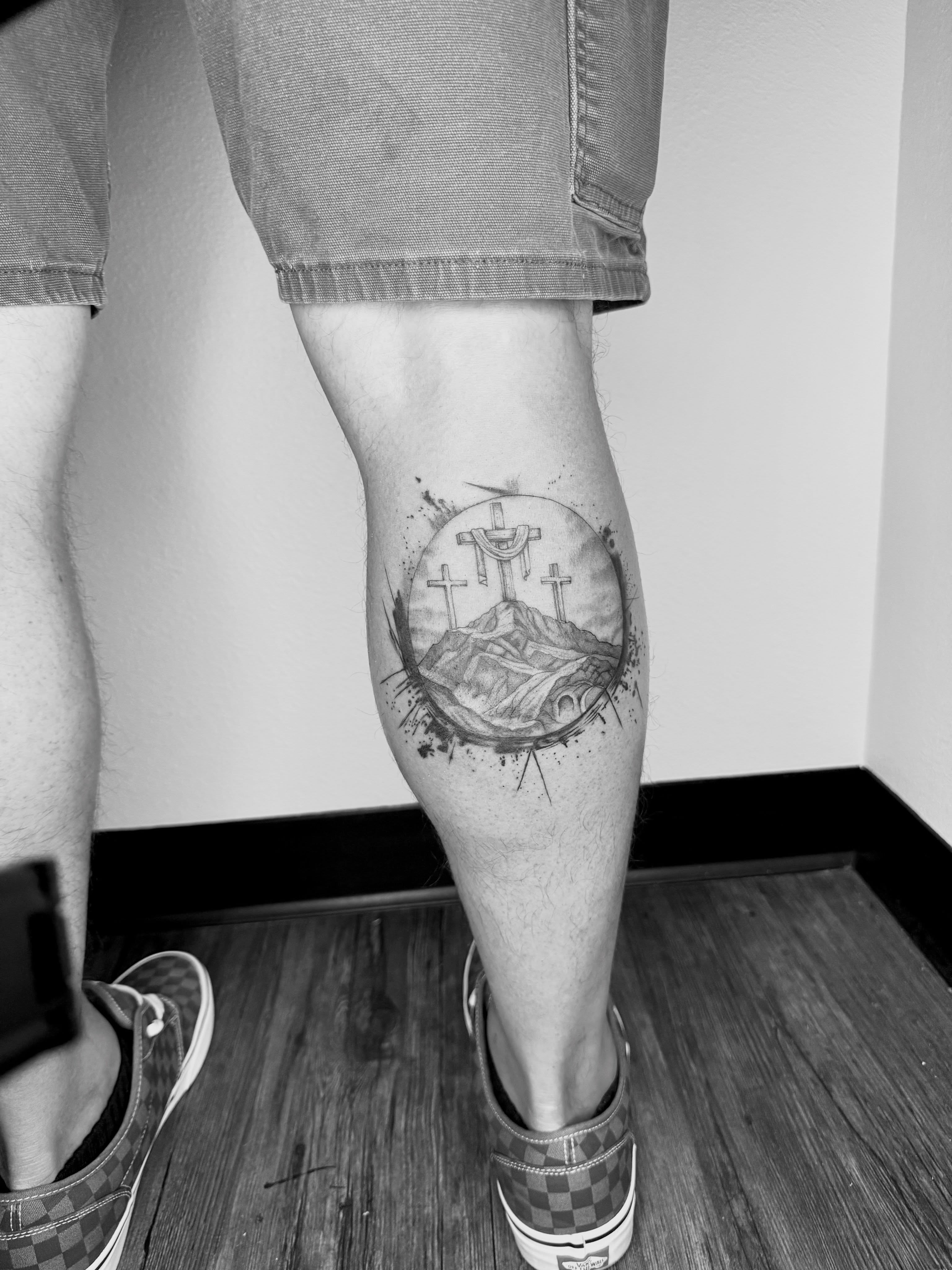 Crosses and mountain black and grey tattoo on the calf by Ashley Limon