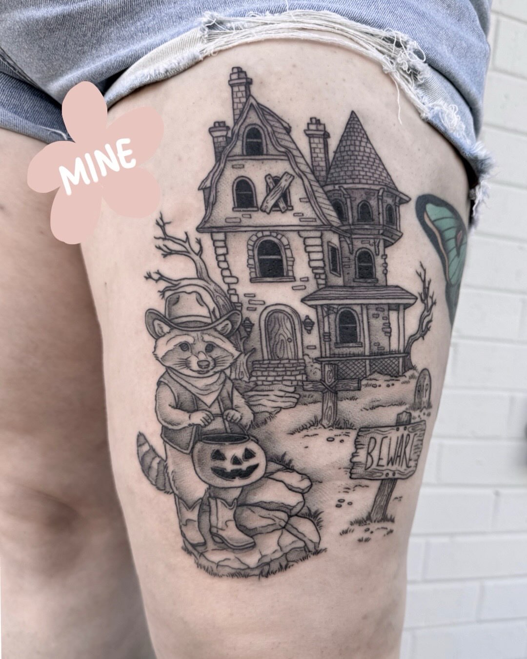 Haunted house and raccoon realism tattoo on the thigh by Audrey Kacel, Holland, Michigan