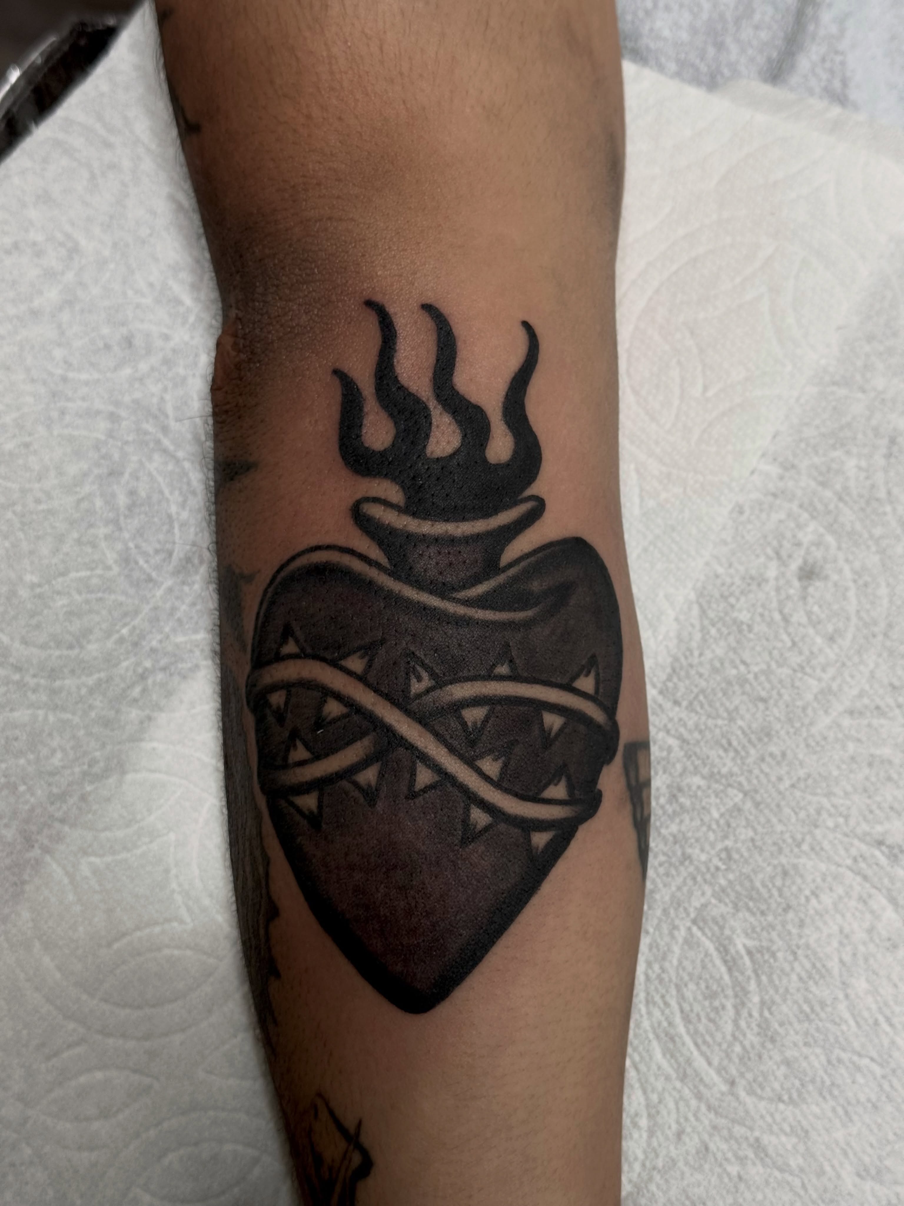 Heart with flames black and grey tattoo on the forearm by San Diego Tattoo Artist - 𝔍𝔞𝔠𝔬𝔟 𝔓𝔞𝔫𝔦𝔞𝔤𝔲𝔞