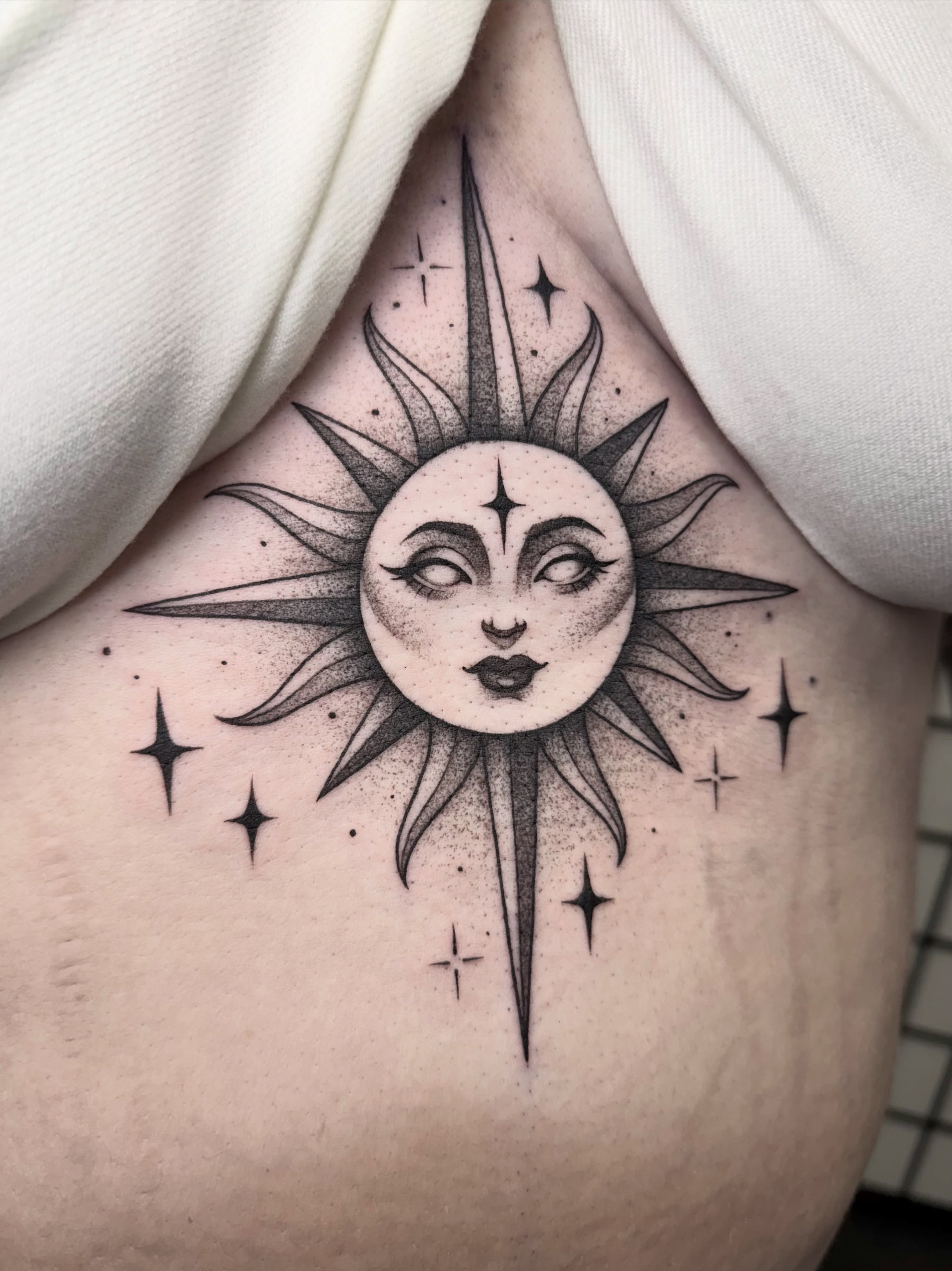 Sun and moon dotwork tattoo on the ribs by Rose Ulinski
