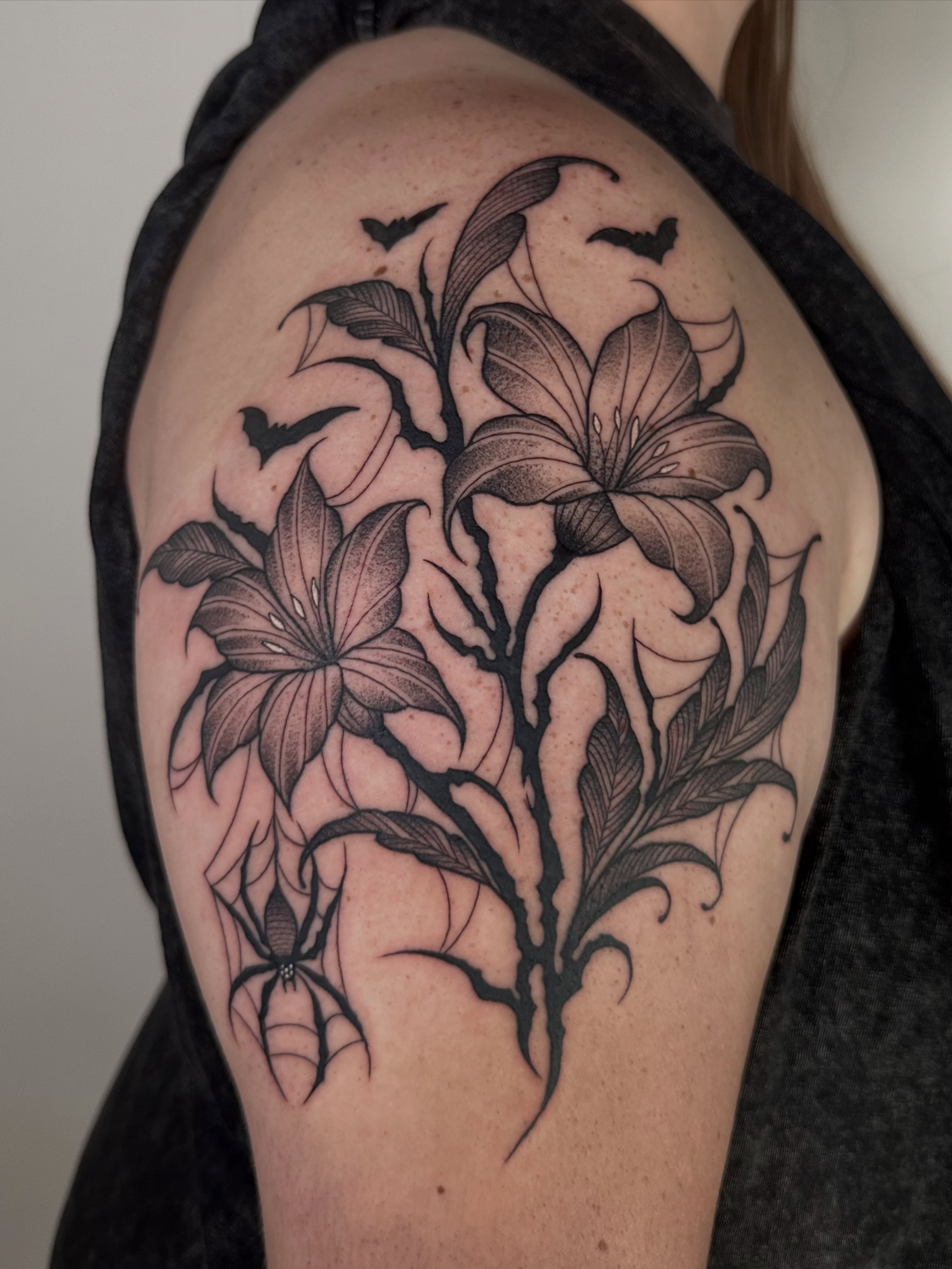 Lilies and spider dotwork tattoo on the shoulder by Brooklyn Bailey